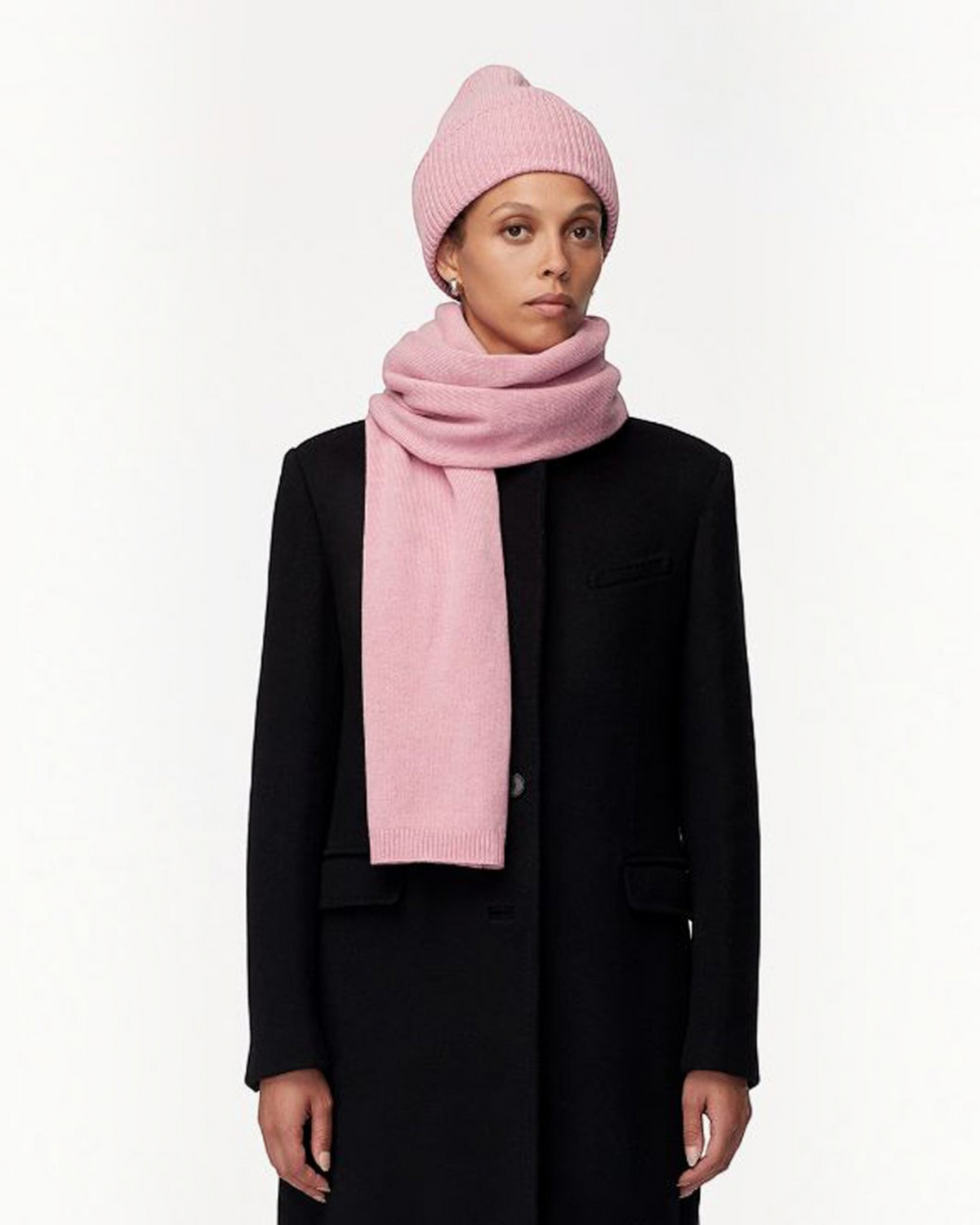 Weldun model wearing a soft orchid pink recycled cashmere scarf and matching ribbed beanie with a black coat