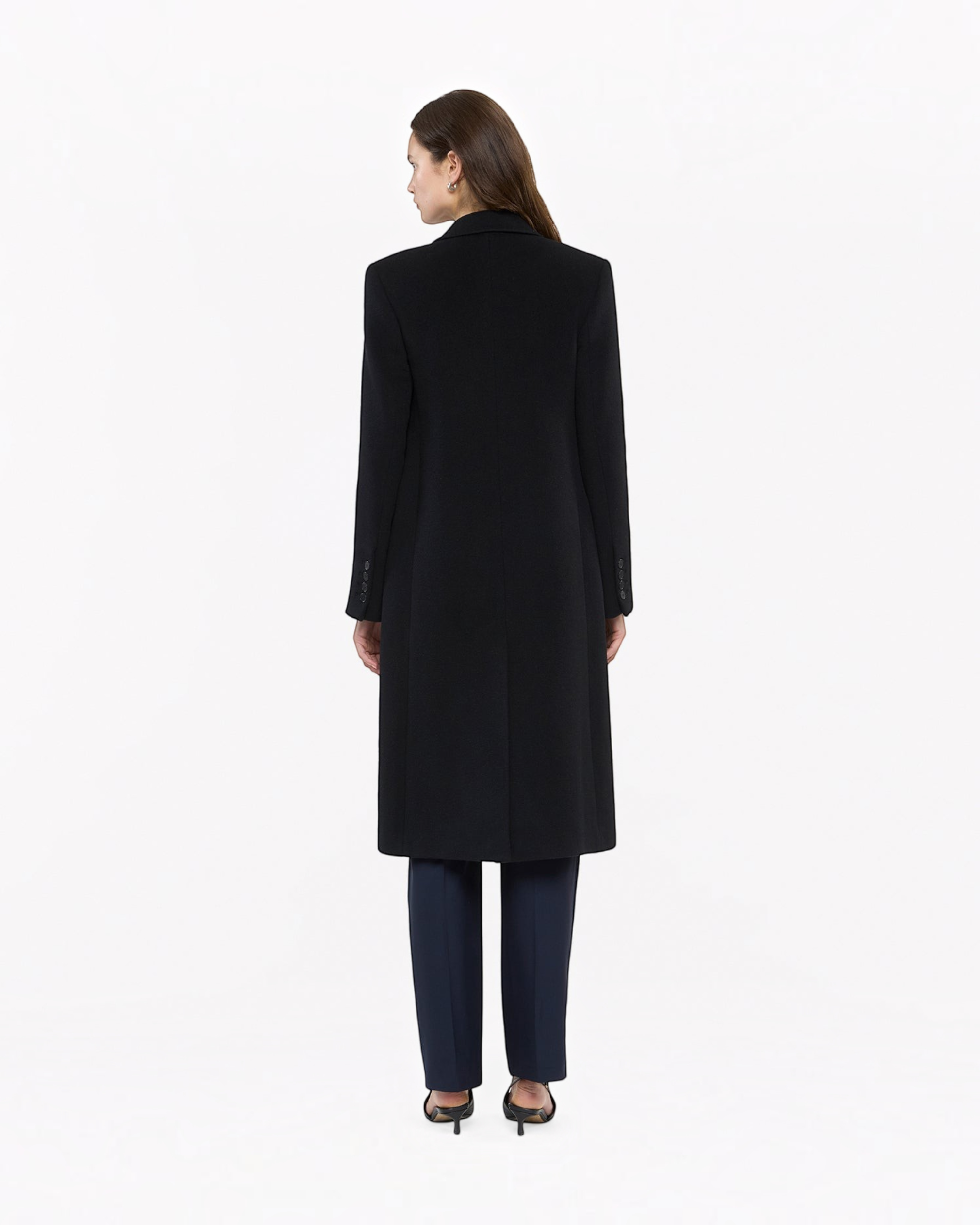 Back view of a Weldun black tailored cashmere overcoat worn by a woman, featuring a sleek, structured silhouette.