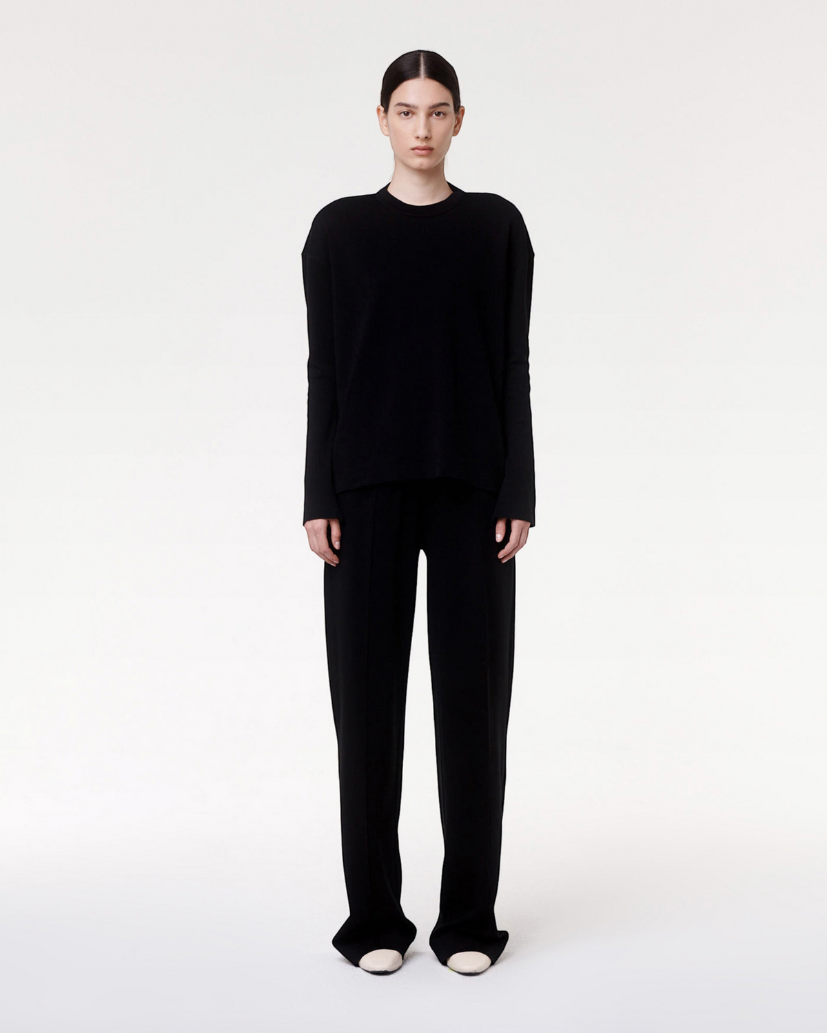 Model wearing Weldun black Luxe Seamed Lounge Pants with pintuck details and a matching long-sleeve top