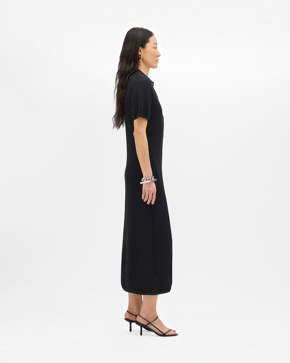 Weldun black midi pique polo dress with button-front closure and short sleeves worn by a model in profile view