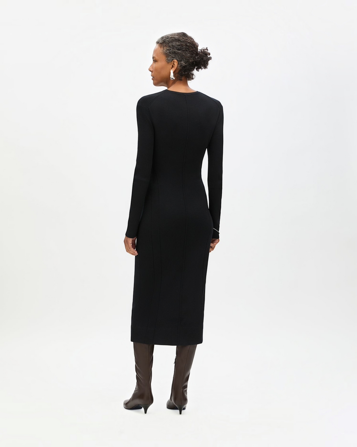 Weldun black tea length rib knit dress with long sleeves and curved seaming worn by a model with brown boots