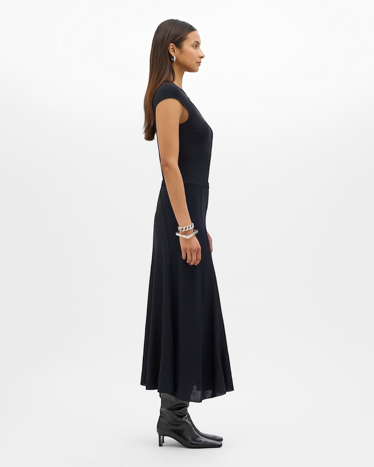 Weldun black midi length seamed knit flare skirt worn by a model in a side profile view