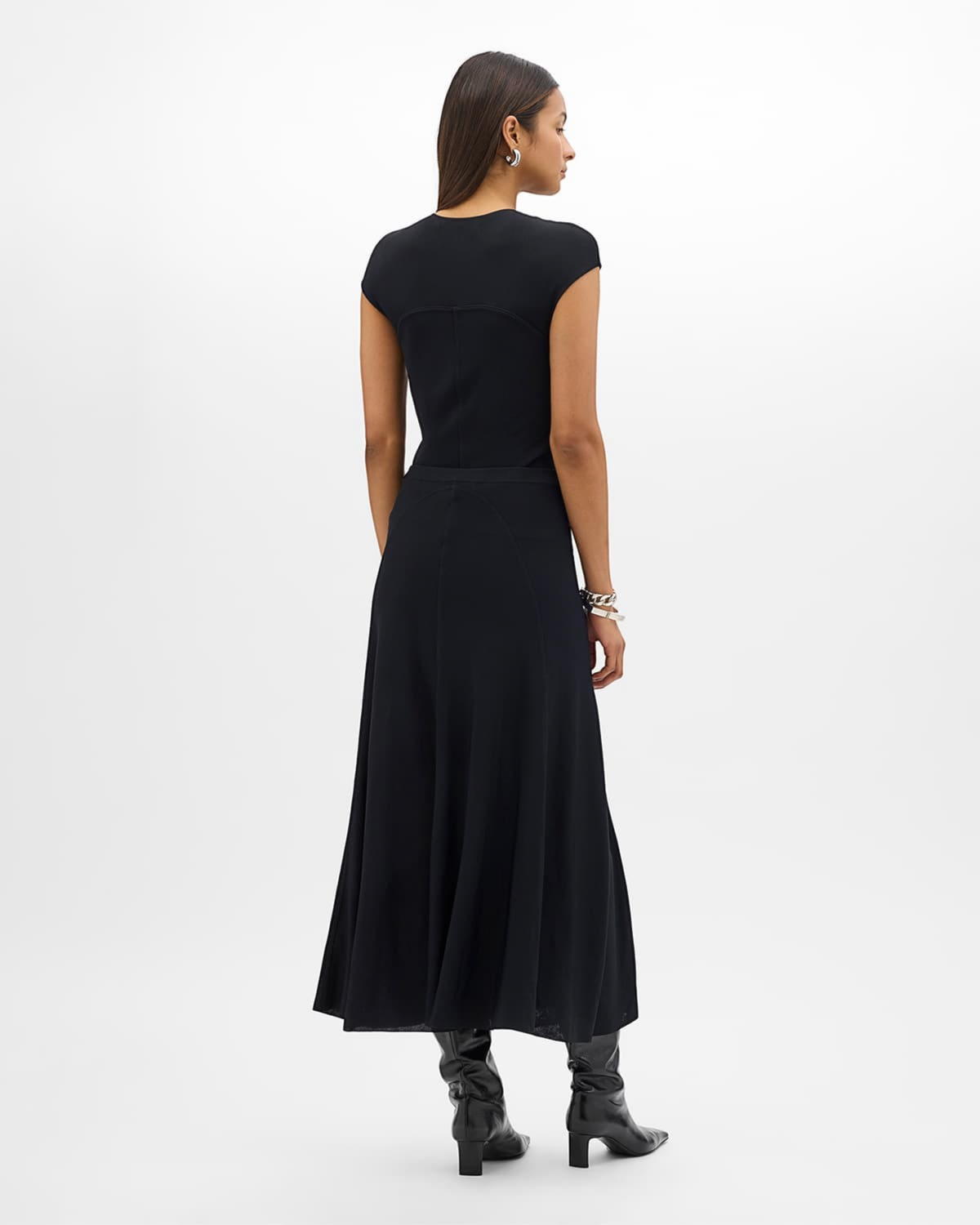 Weldun black midi-length seamed knit flare skirt worn by a model from the back view with black boots