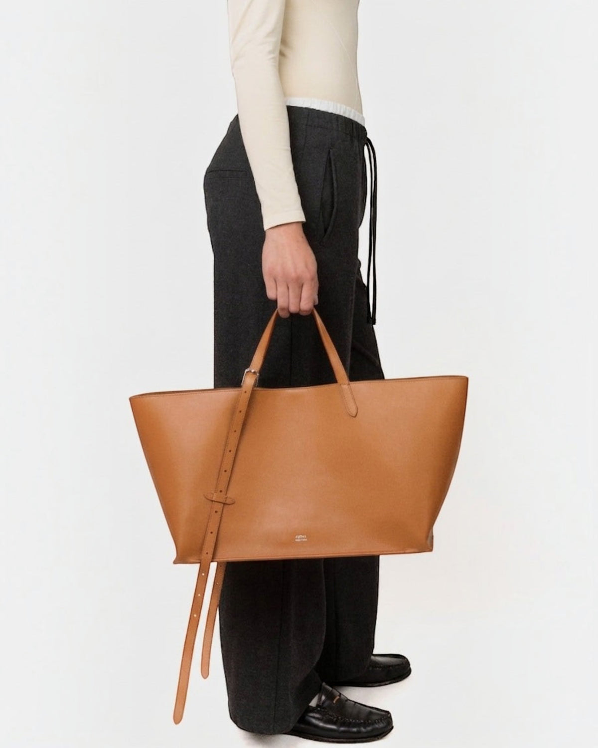 Weldun Leonora Day soft tan Italian nappa leather tote bag with adjustable stirrup buckle straps held by a model