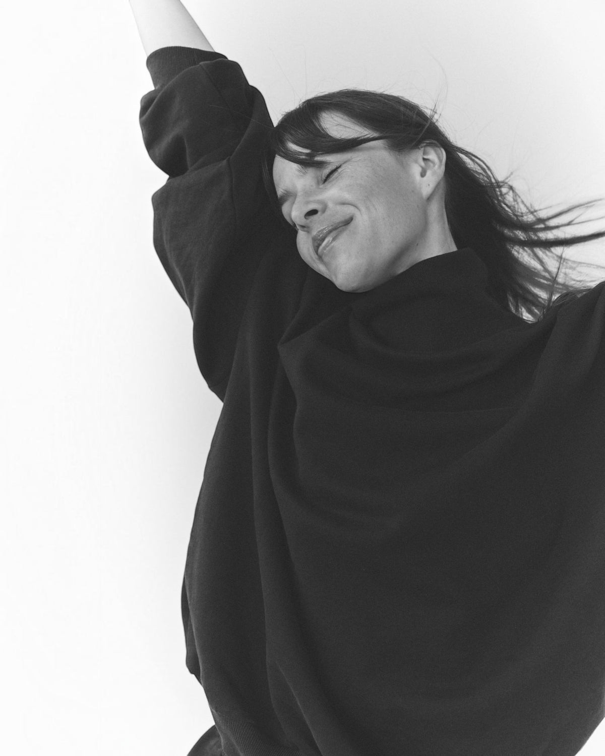 Weldun navy organic cotton high neck sweatshirt with a relaxed, boxy fit worn by a smiling woman.