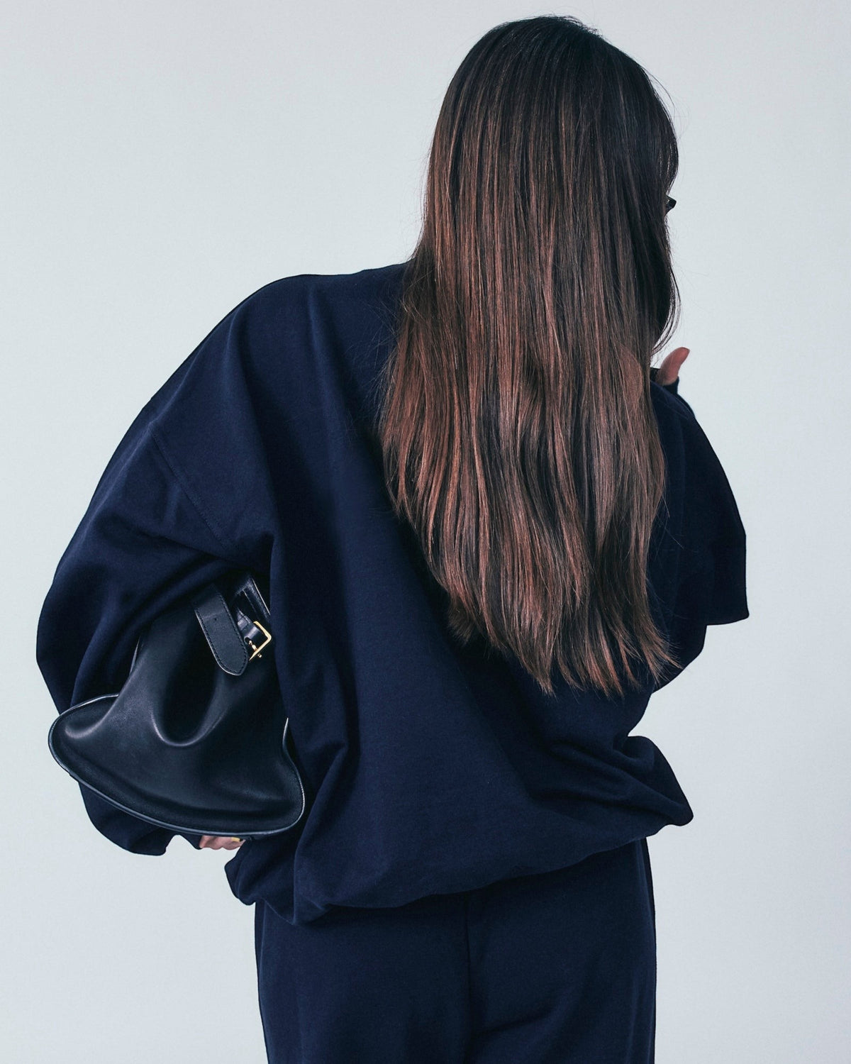 Weldun navy organic cotton high neck sweatshirt with a relaxed, boxy fit worn by a person with long brown hair.