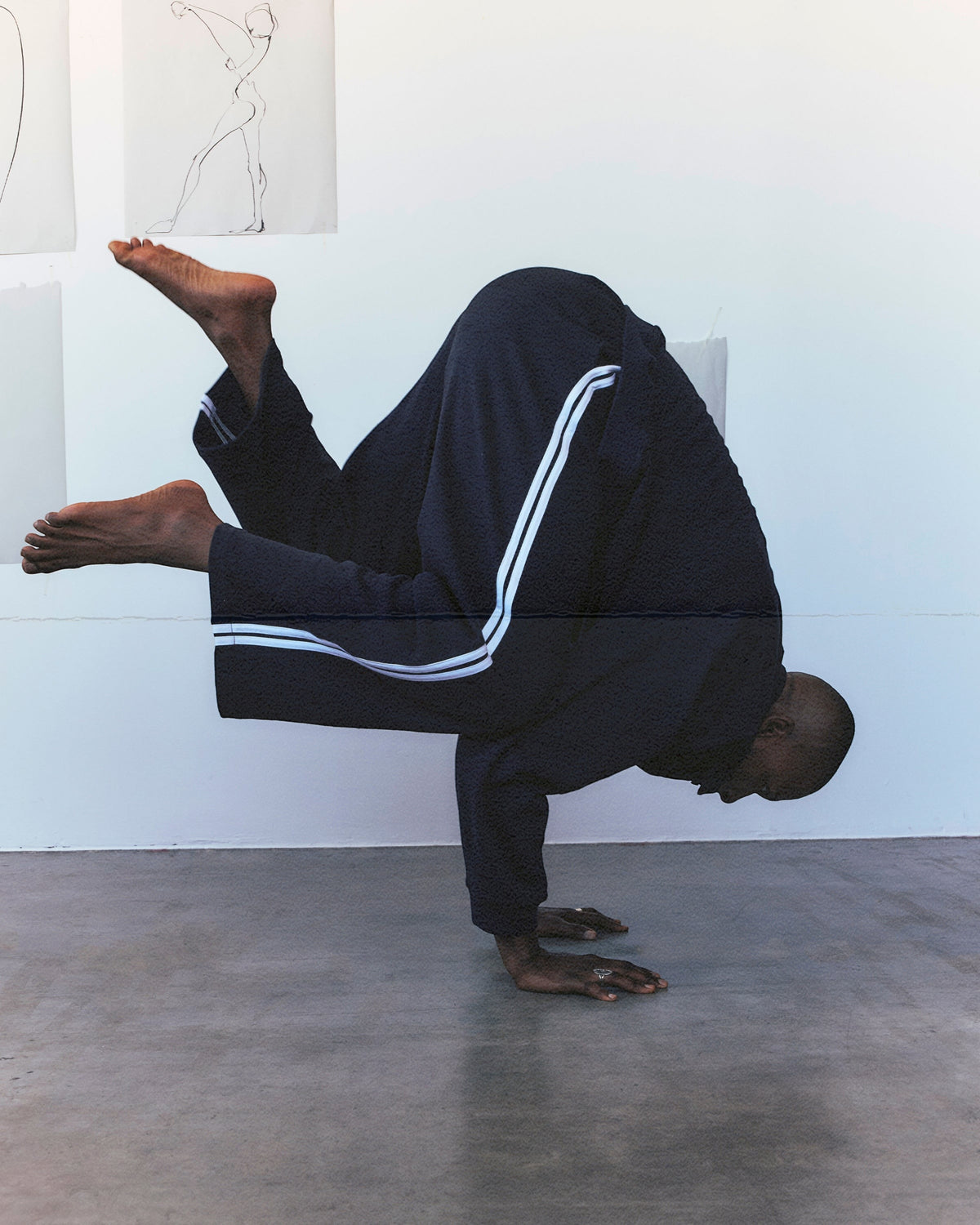 Weldun navy cotton terry track pants with white side stripes worn by a person performing a handstand