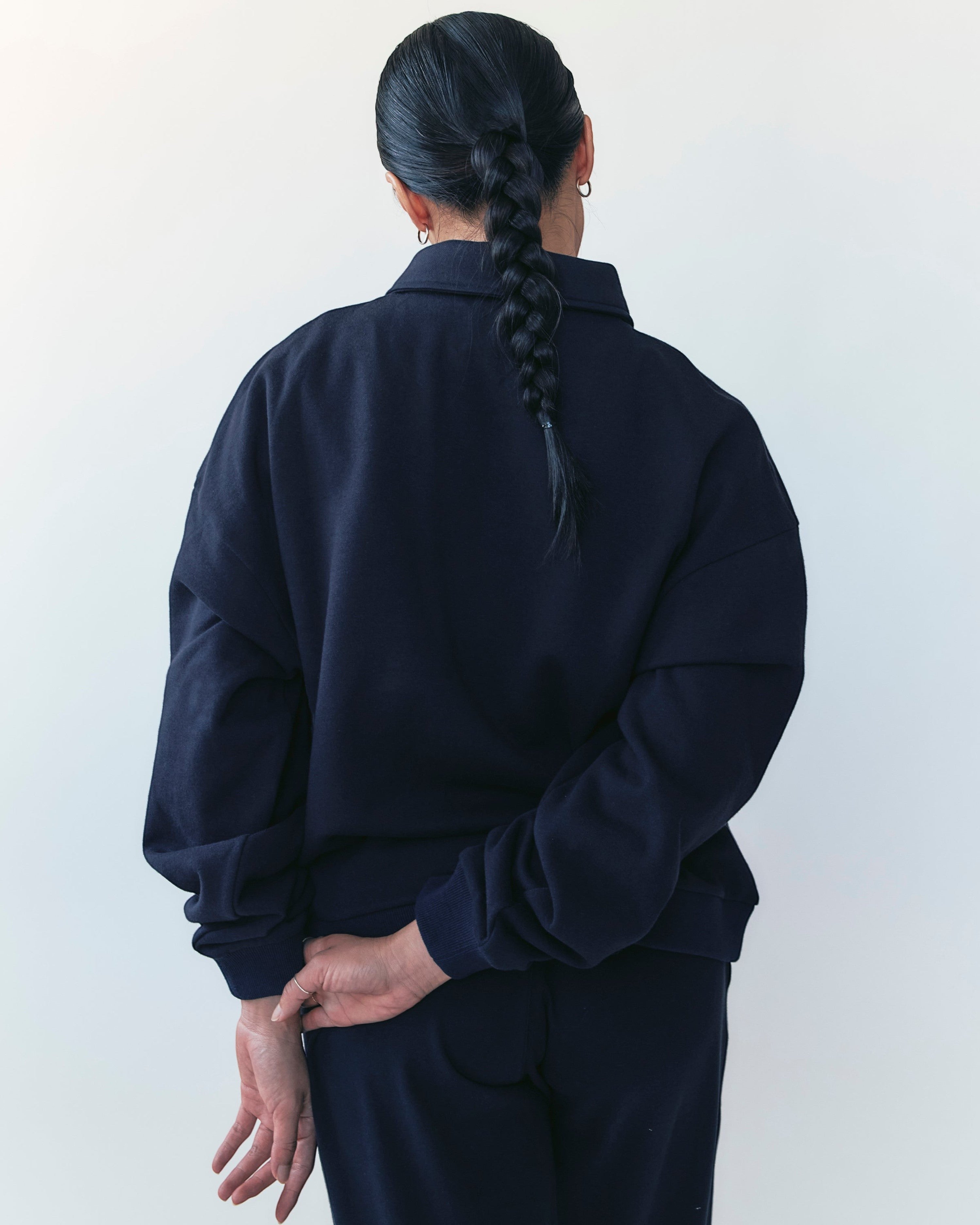 Weldun navy oversized polo sweatshirt with ribbed collar and cuffs worn by a model with a braided ponytail, back view