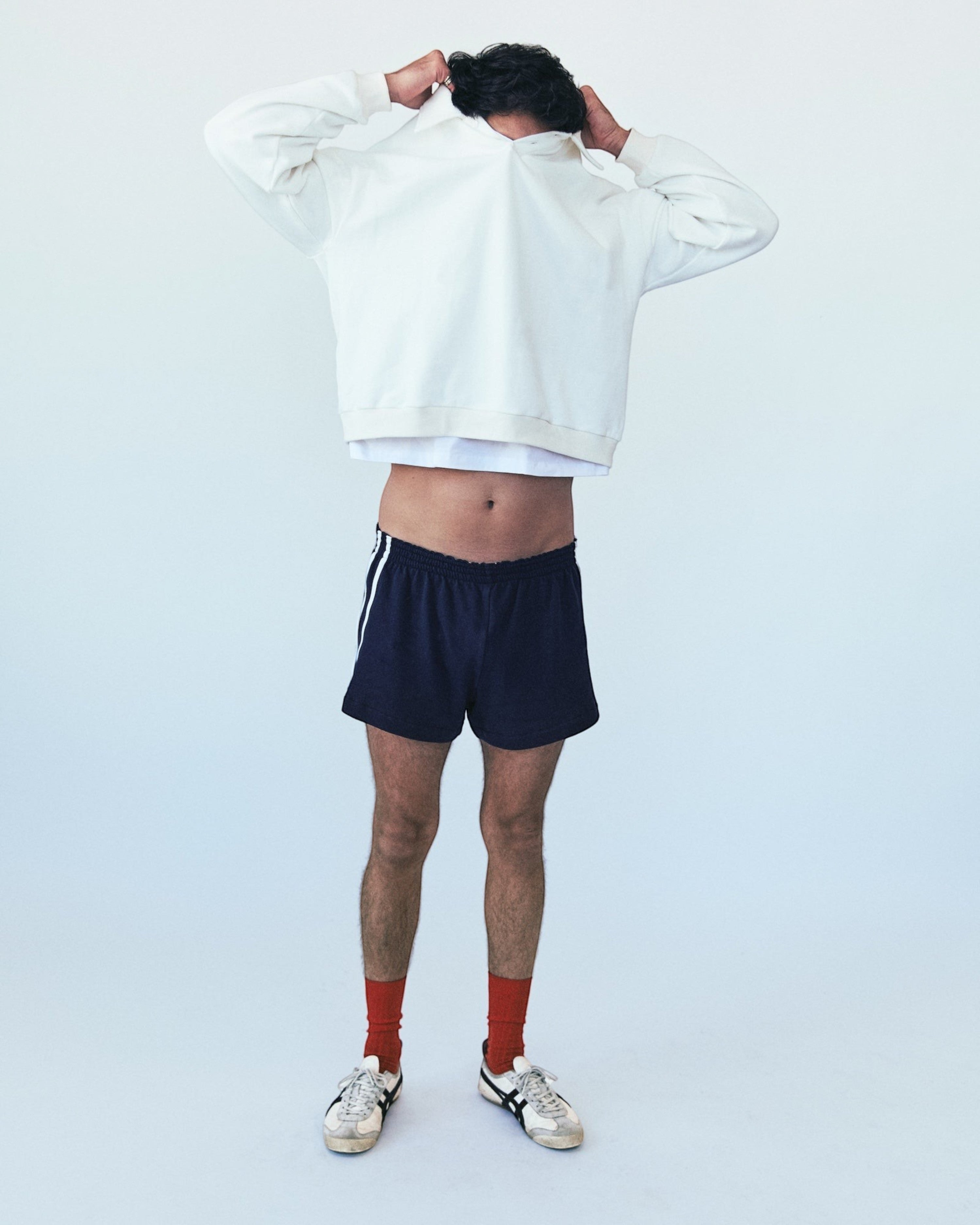 Weldun H-O-R-S-E navy cotton terry basketball shorts with white side stripes worn by a model in a studio setting