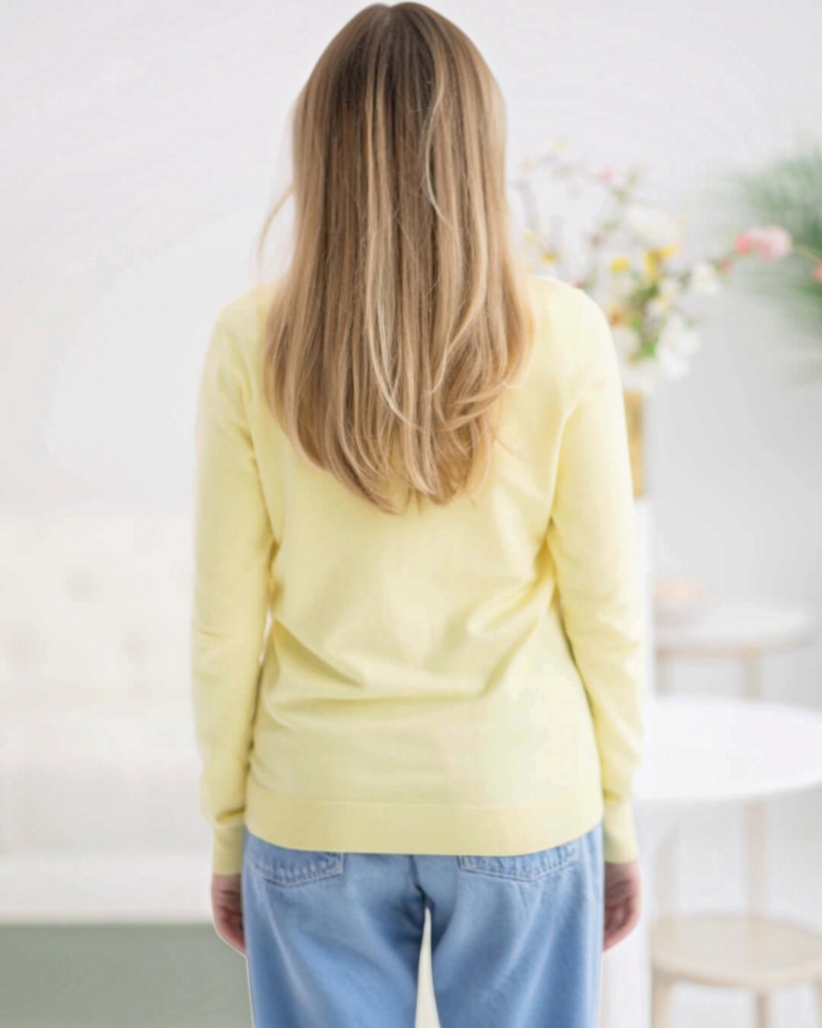 Weldun model wearing a yellow adaptive knit cardigan sweater from behind, showing a soft rayon-nylon blend fabric.