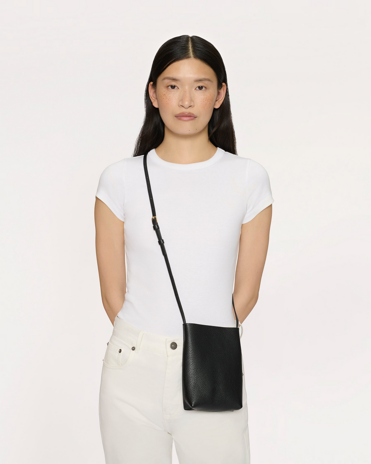 Weldun Mansur Gavriel black pebbled leather Everyday Cabas crossbody bag worn by a model in a white t-shirt