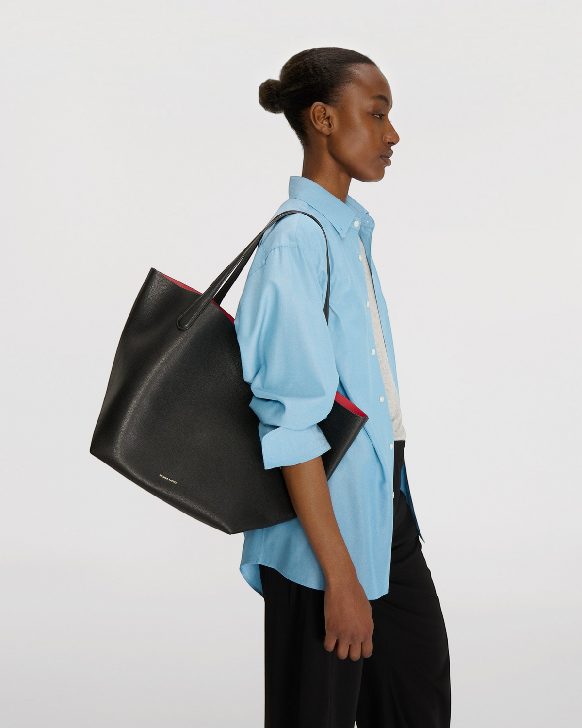 Weldun Mansur Gavriel Everyday Soft Tote in black pebbled nubuck leather with a vibrant red interior on a model