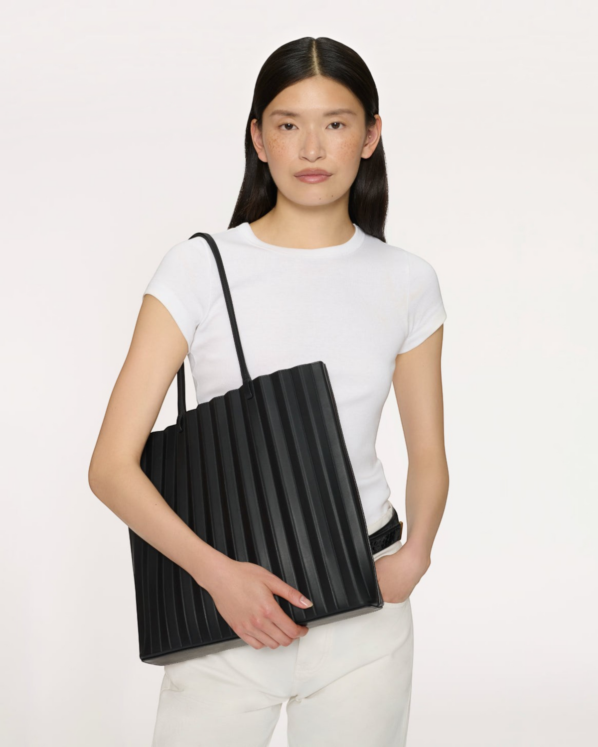 Weldun Mansur Gavriel large black pleated leather Filo tote bag with shoulder straps held by a model