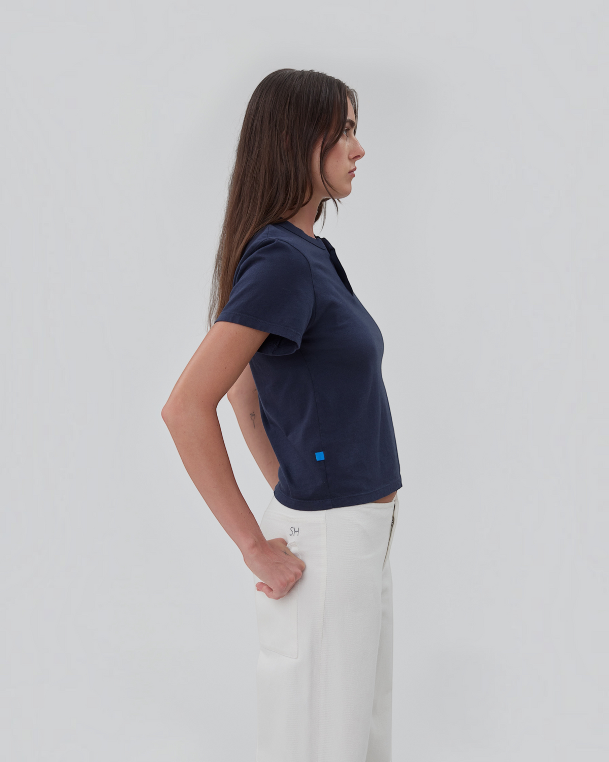 Weldun Still Here navy blue cotton short sleeve Henley shirt with two-button placket worn by a model, side view.