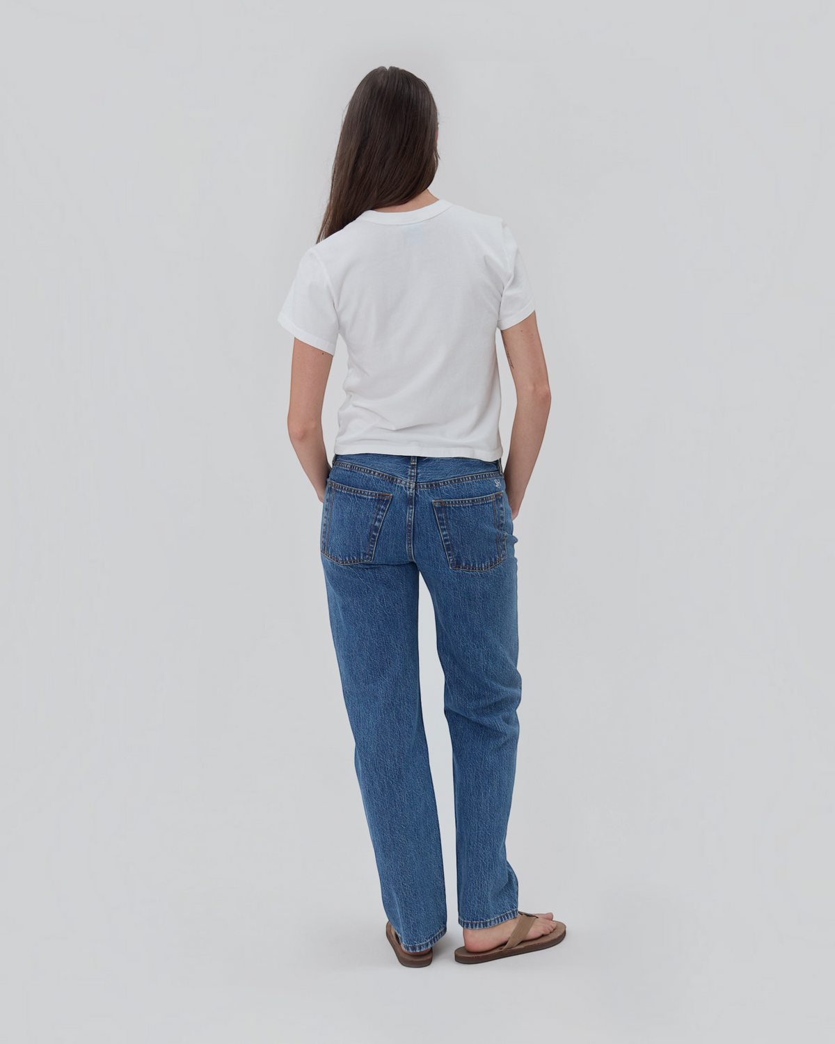 Weldun Still Here white cotton short sleeve Henley shirt worn by a woman with blue jeans, back view