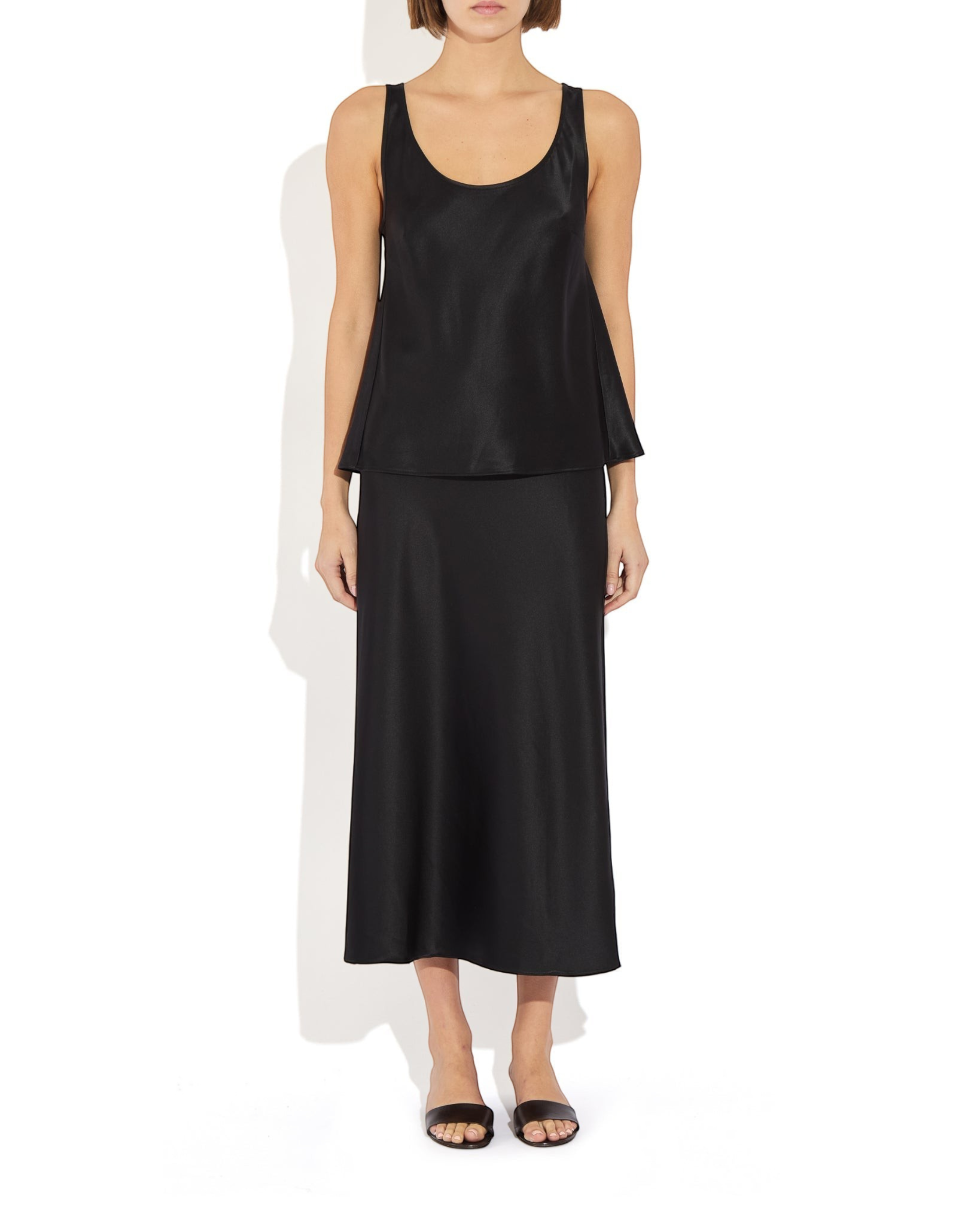 Weldun Karen Tank in black stretch silk with a scooped neckline, worn with a matching skirt on a model.