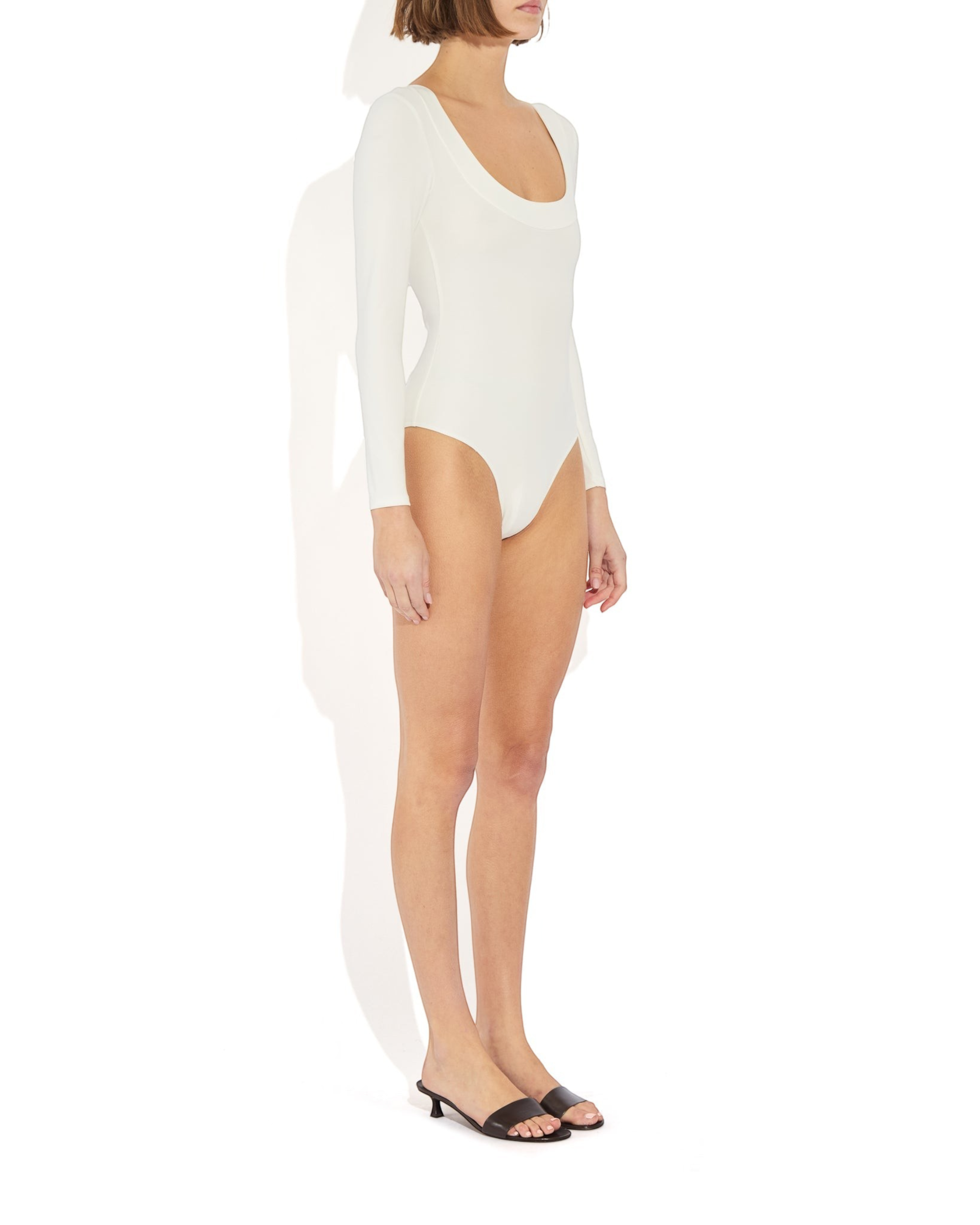 Weldun Maranda long-sleeve white bodysuit with a low scoop neckline and tuxedo-inspired banded trim on a model