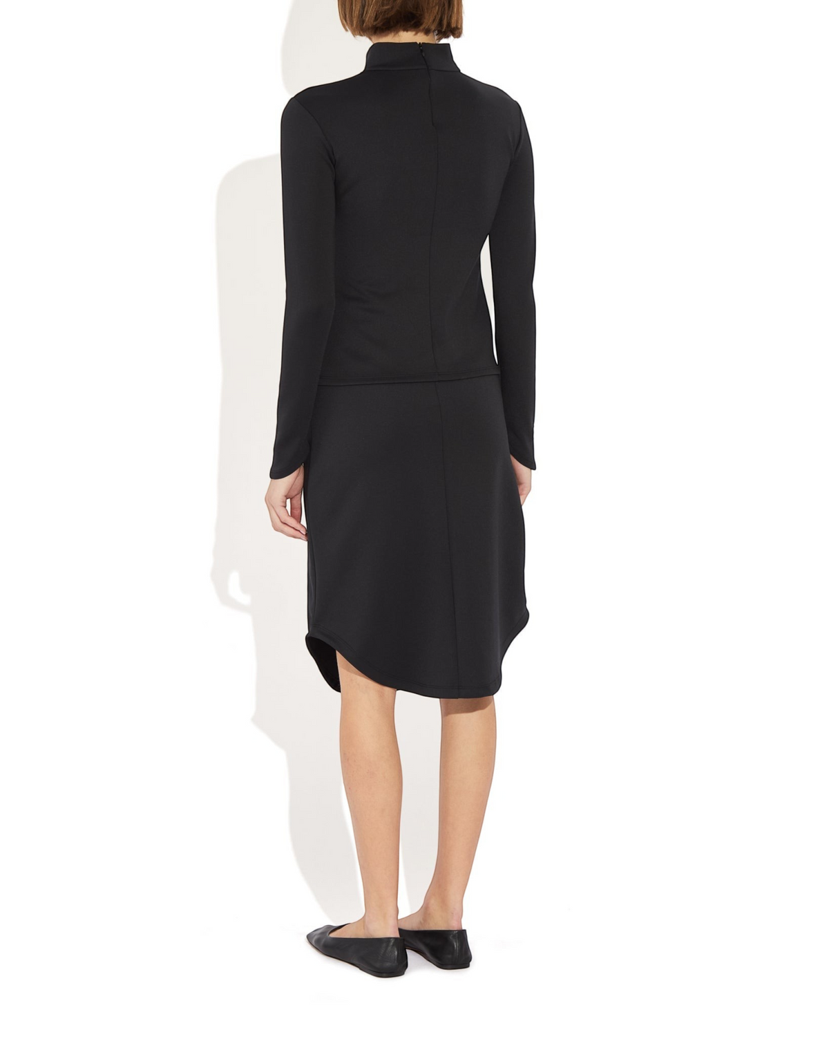 Weldun Rose Skirt in black stretch recycled-poly blend with a sculptural rounded hem, back view on a model