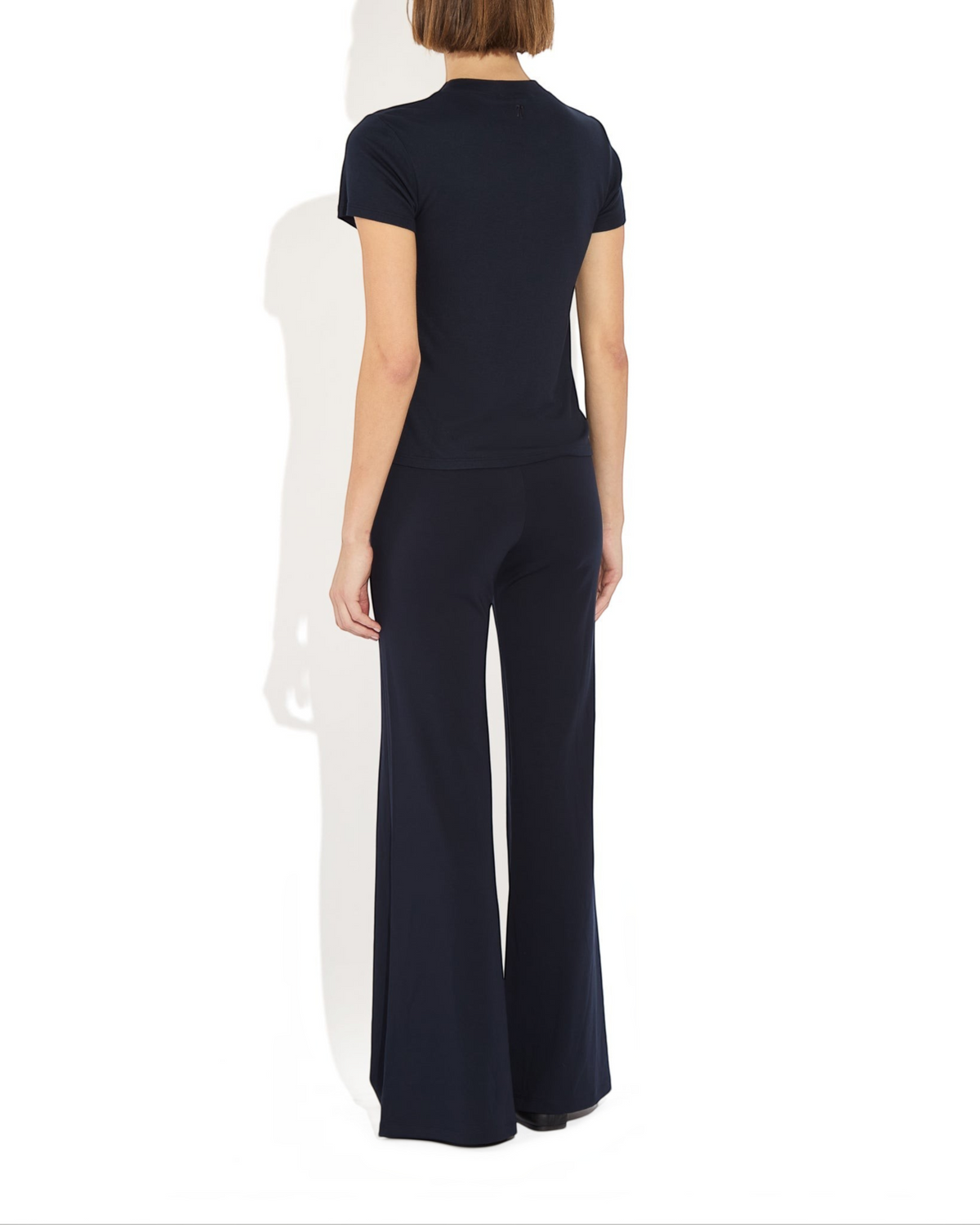 Weldun Tessa Long Pant in navy blue with a high elastic waist and fluid flare leg, shown from the back view.