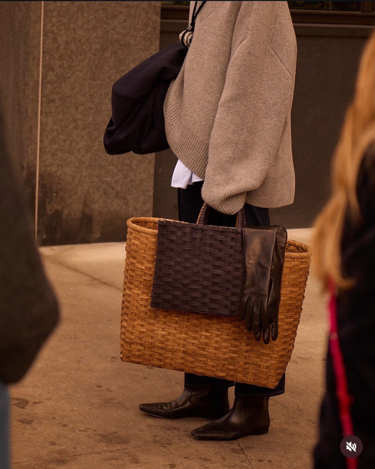 Weldun Big Shopper oversized rattan basket bag with a dark woven pocket detail carried by a person in a grey sweater