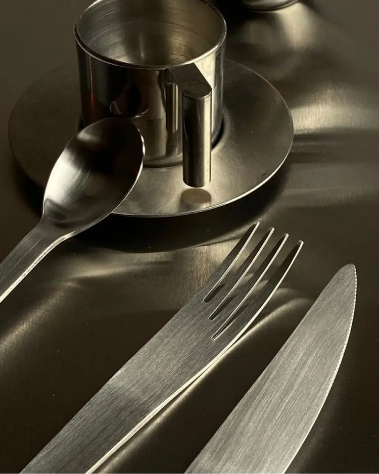 Stainless steel cutlery set on a reflective surface