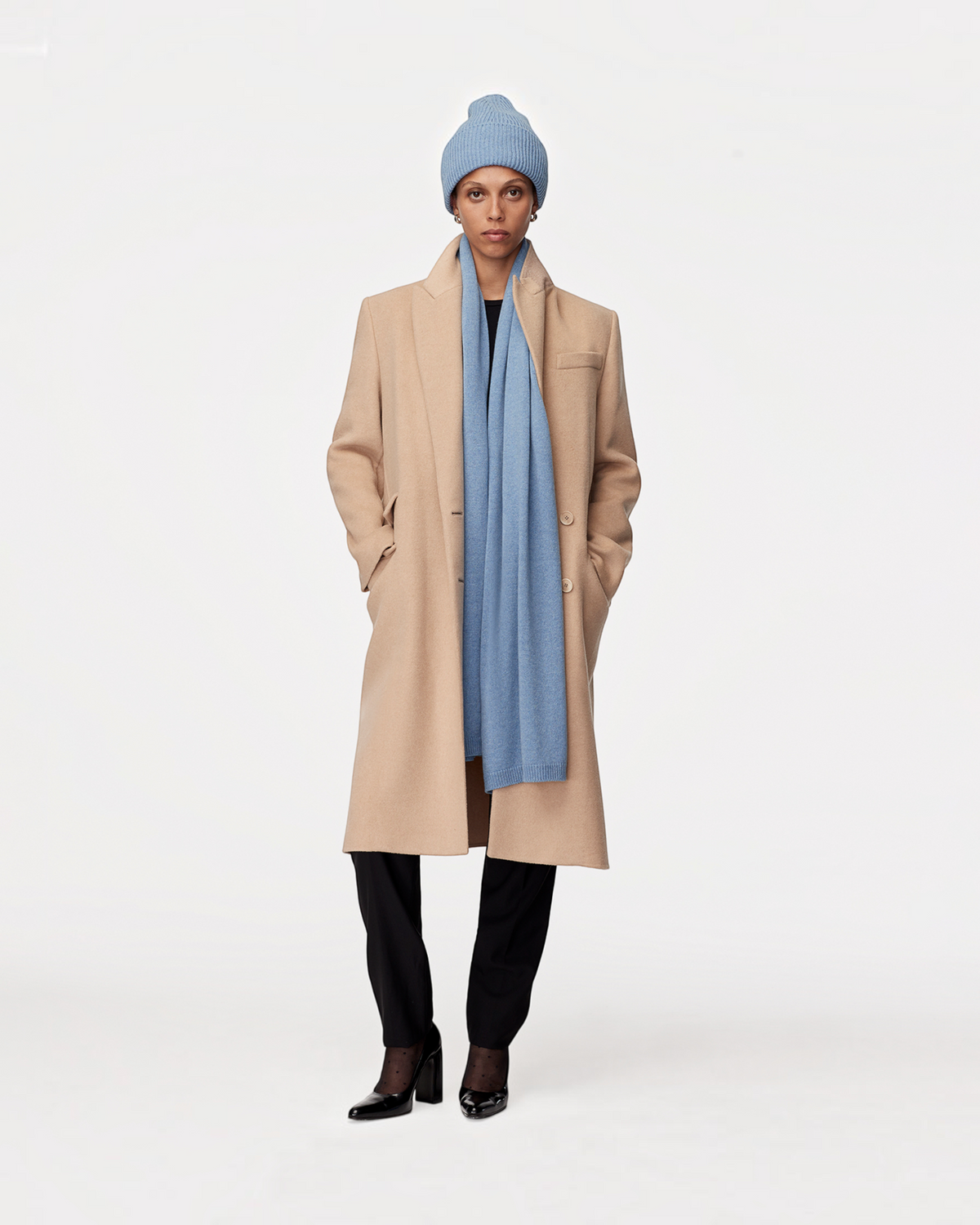 Weldun cornflower blue recycled cashmere scarf worn by a model in a beige wool coat and matching beanie