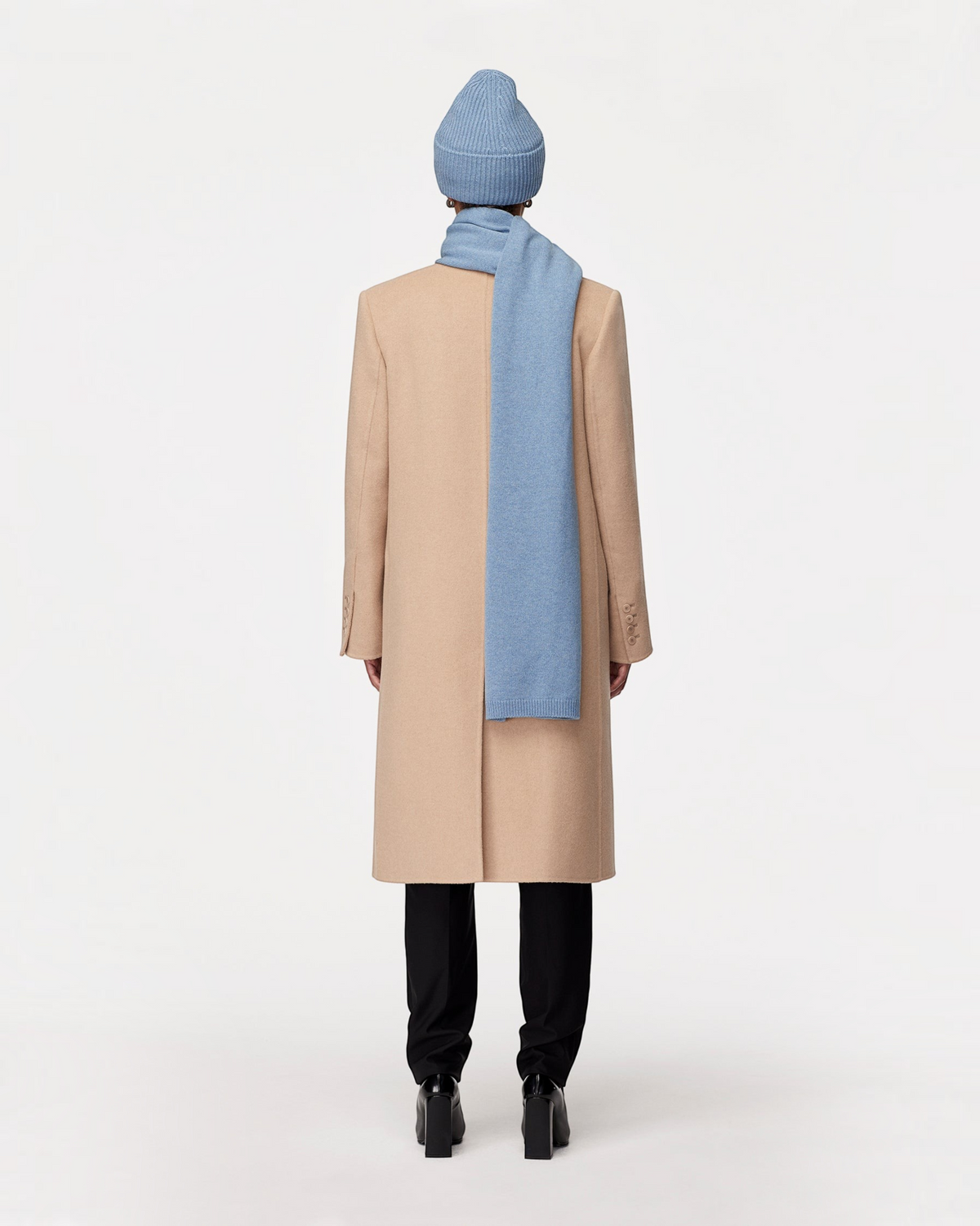 Weldun cornflower blue recycled cashmere scarf worn over a beige wool coat and matching beanie, back view