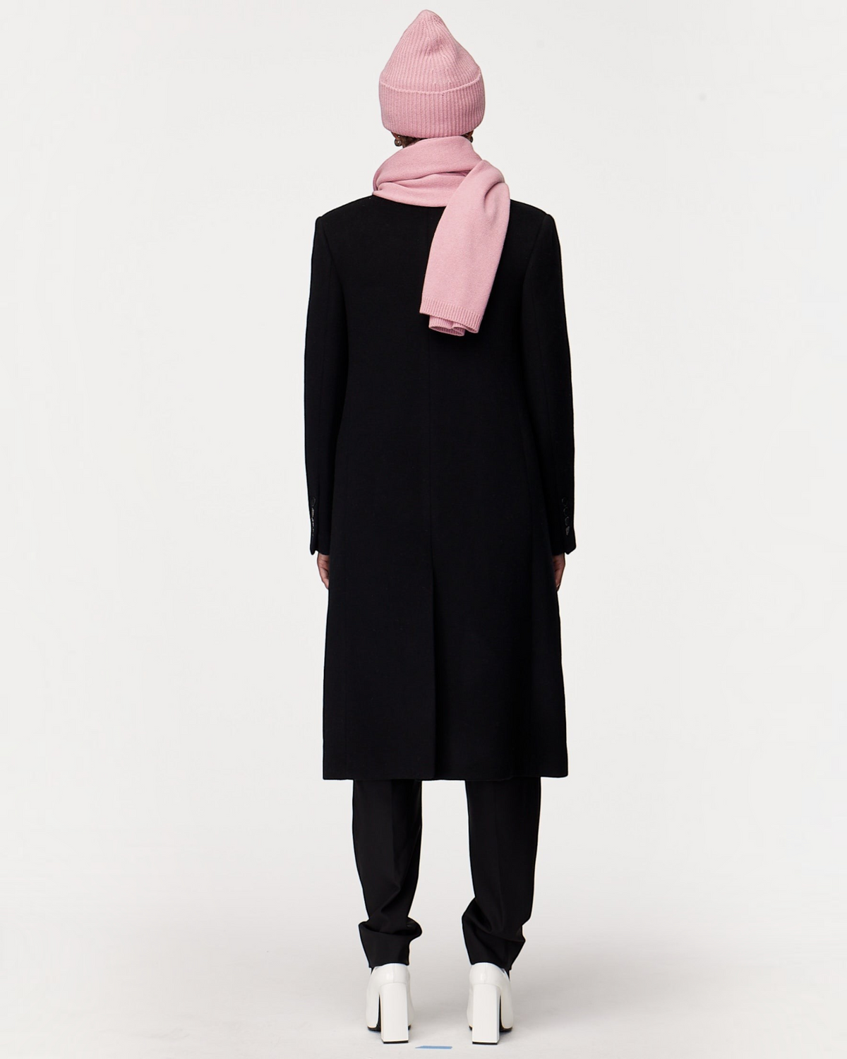 Weldun orchid recycled cashmere scarf worn with a matching beanie and a long black coat, back view