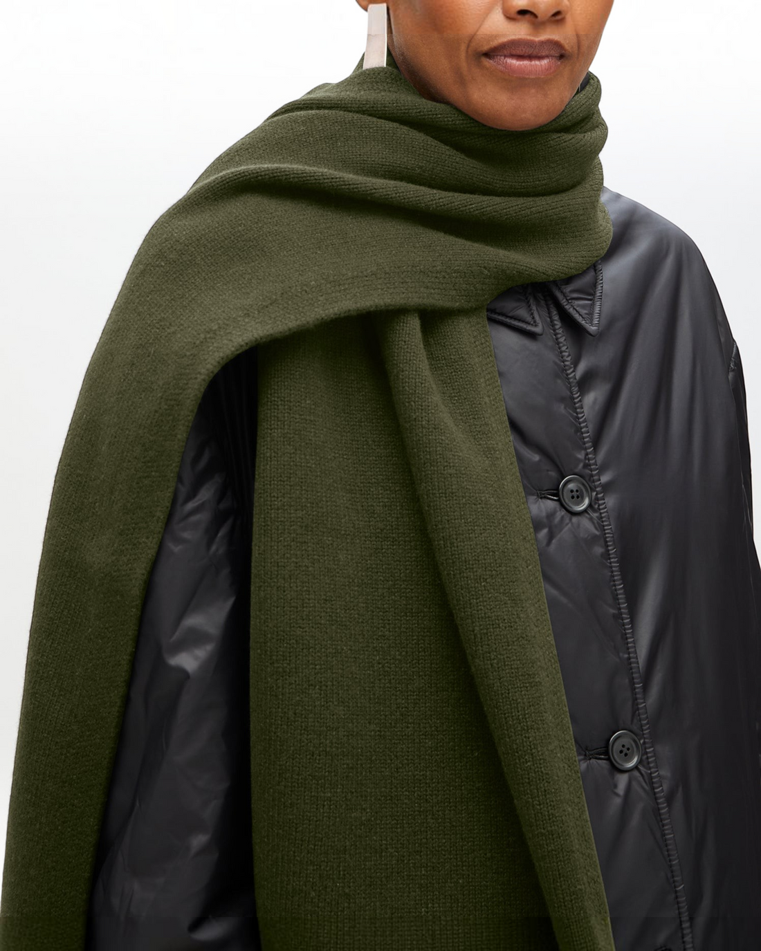 Weldun moss green recycled cashmere shawl scarf draped over a model wearing a black quilted jacket