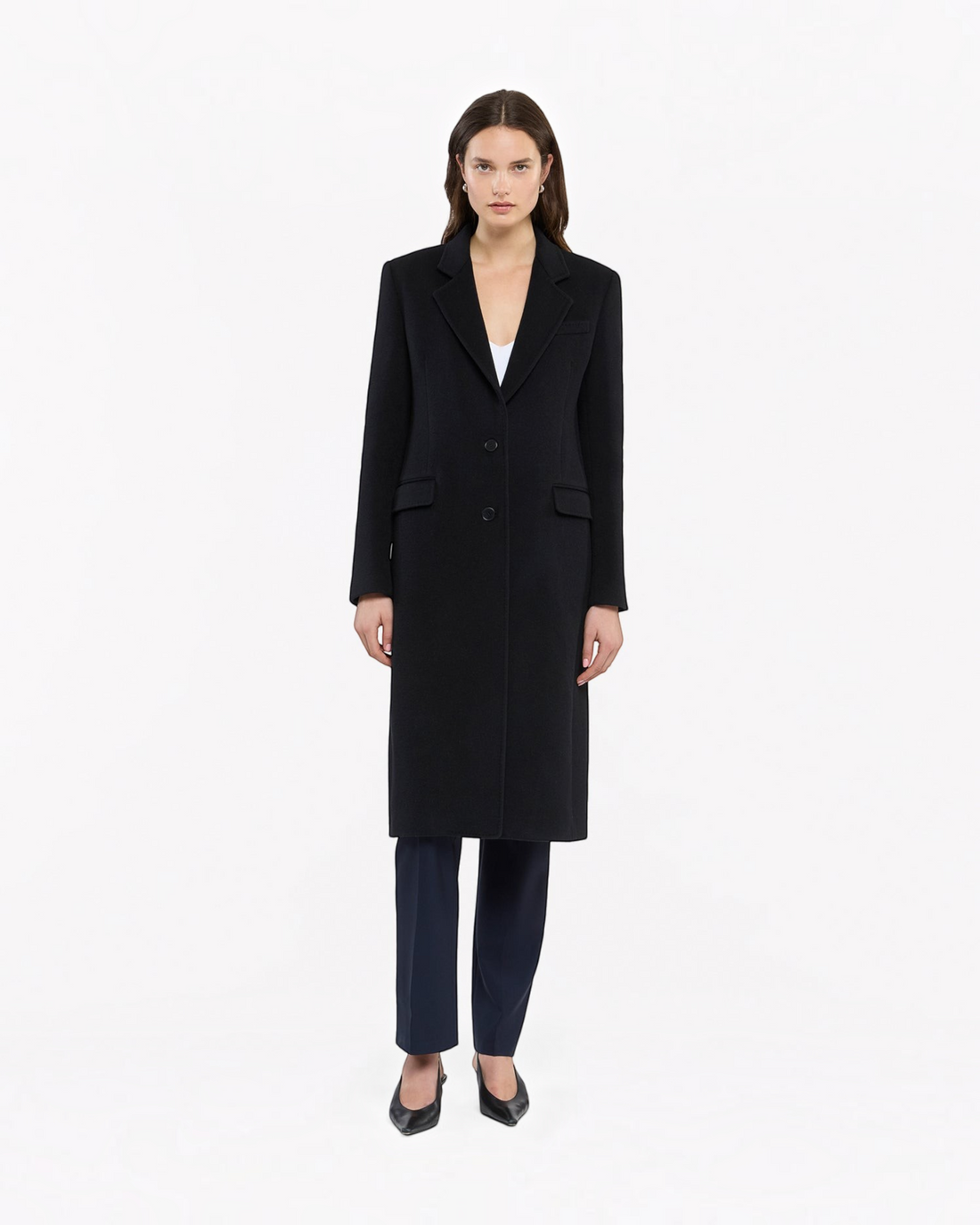 Model wearing a black Weldun cashmere tailored overcoat with a sharp silhouette and button closure