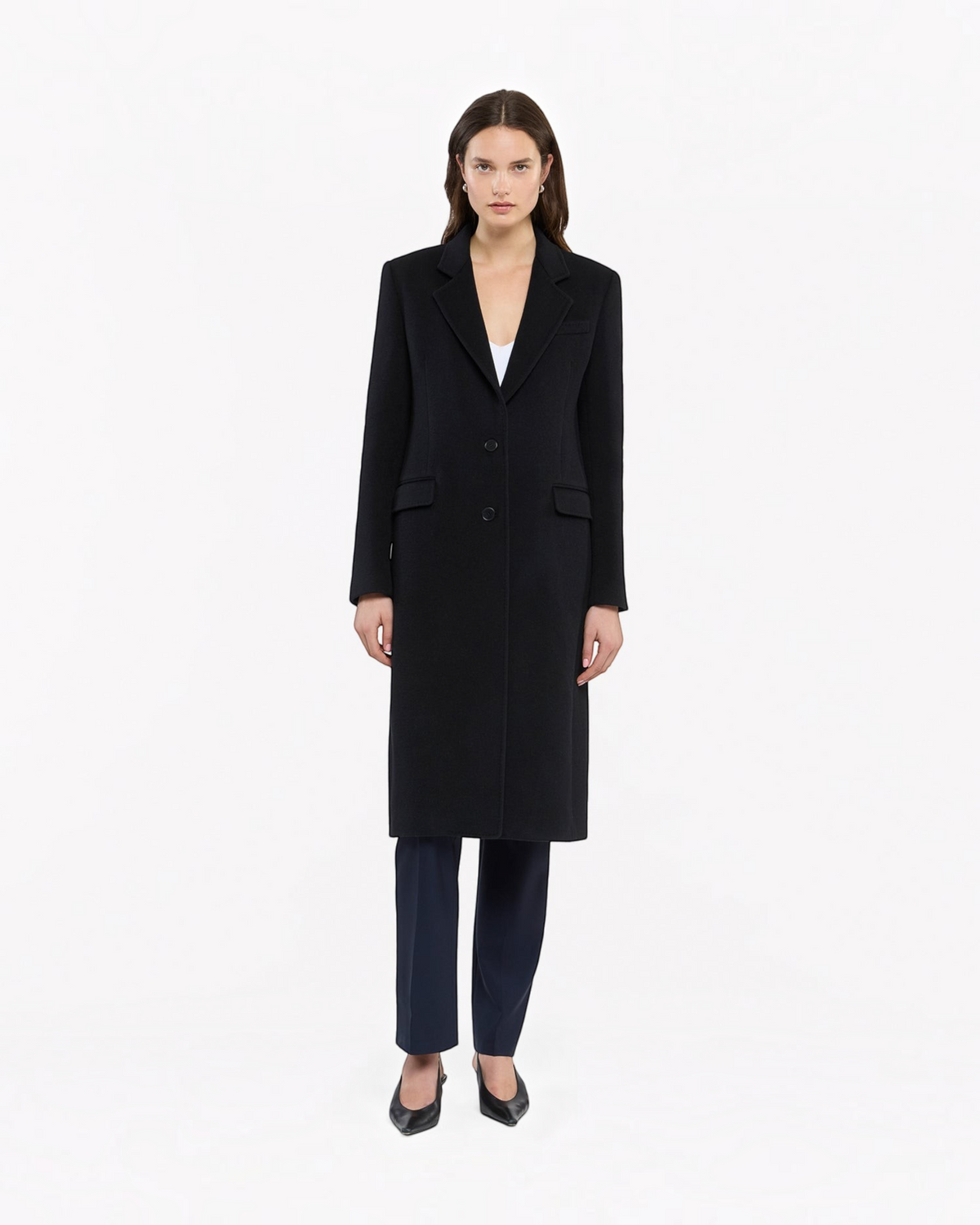 Model wearing a black Weldun cashmere tailored overcoat with a sharp silhouette and button closure