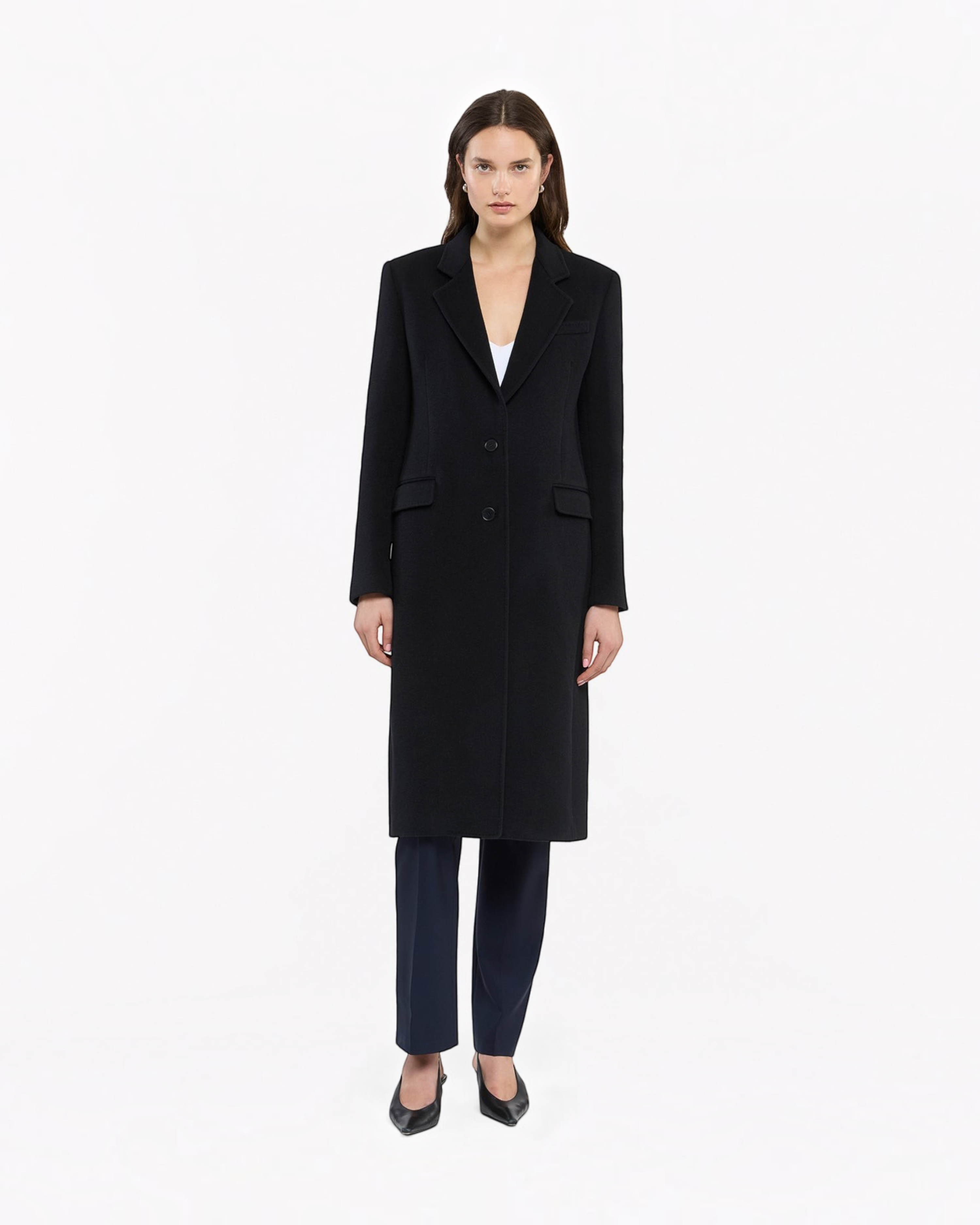 Model wearing a black Weldun cashmere tailored overcoat with a sharp silhouette and button closure