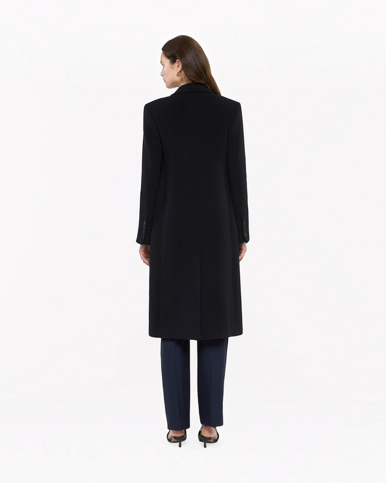 Back view of a Weldun black tailored cashmere overcoat worn by a woman, featuring a sleek, structured silhouette.