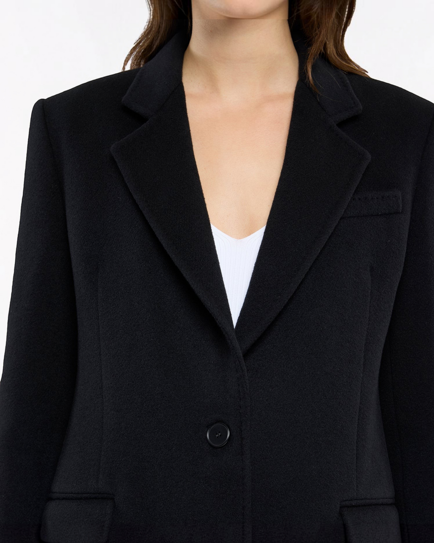Weldun black tailored cashmere overcoat with notched lapels and single-button closure worn over a white top