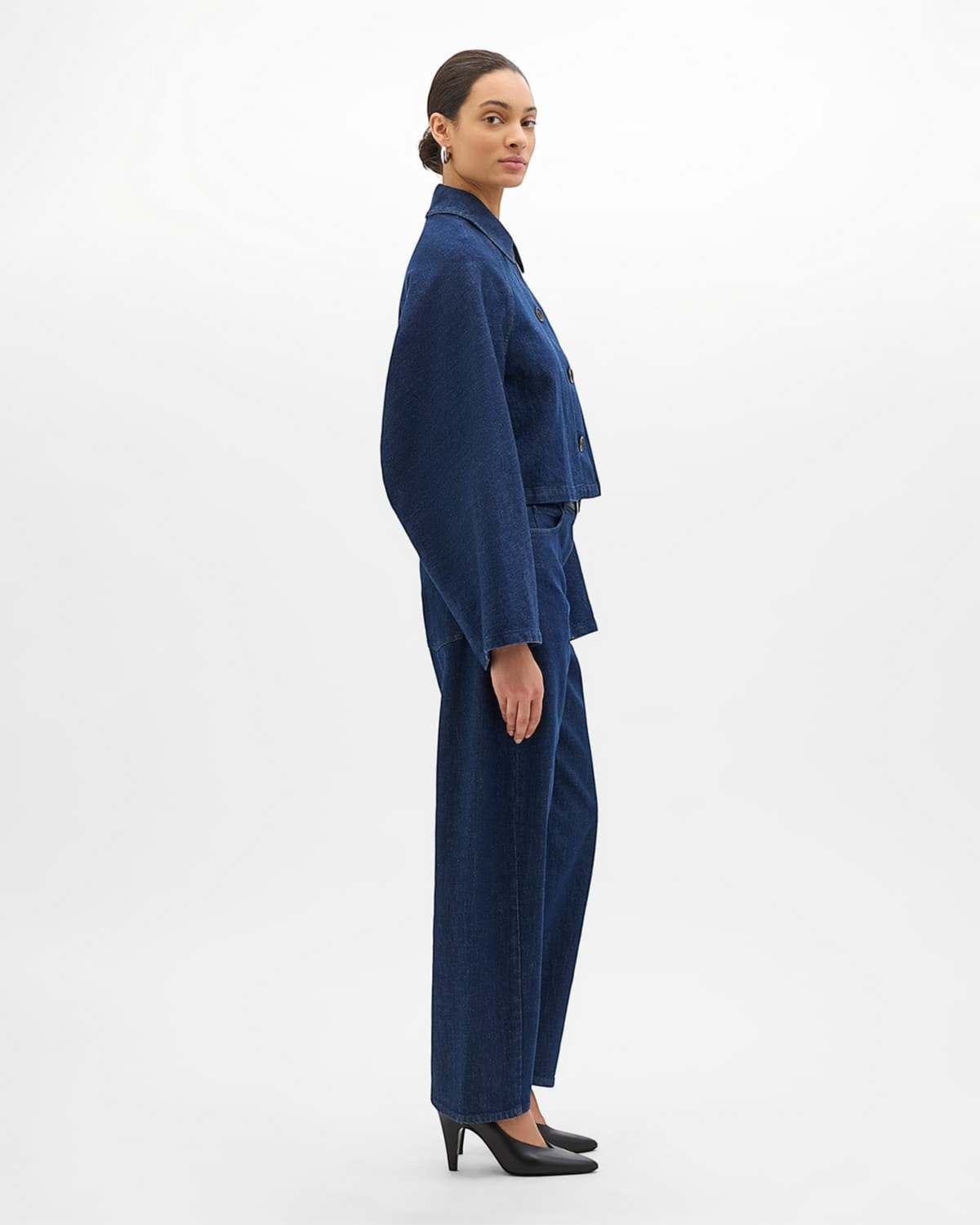Model wearing a Weldun indigo blue organic cotton cropped denim blouson with a relaxed fit and point collar