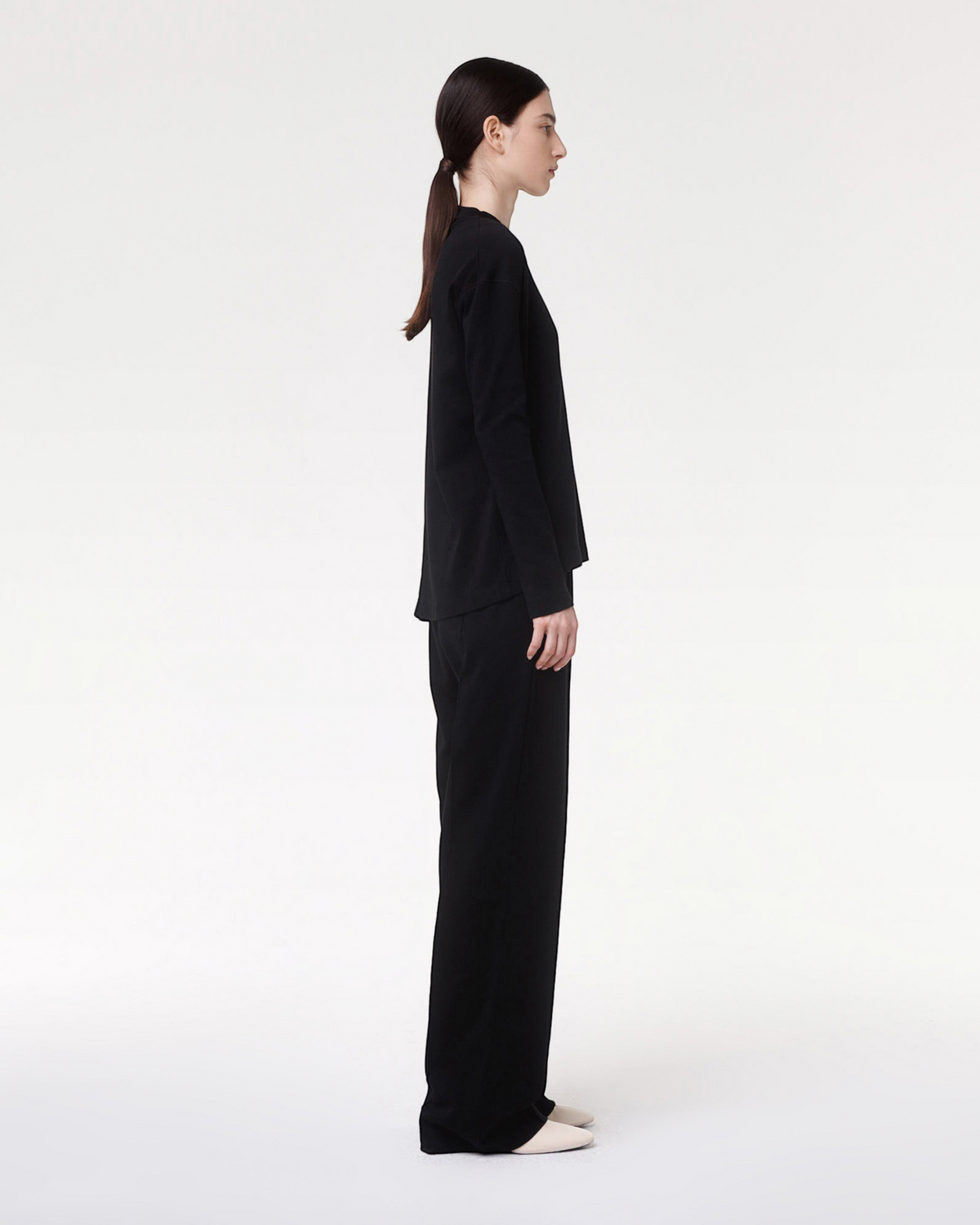 Weldun Luxe Seamed Lounge Pant in black worn by a model in a side profile view showing the straight-leg fit.