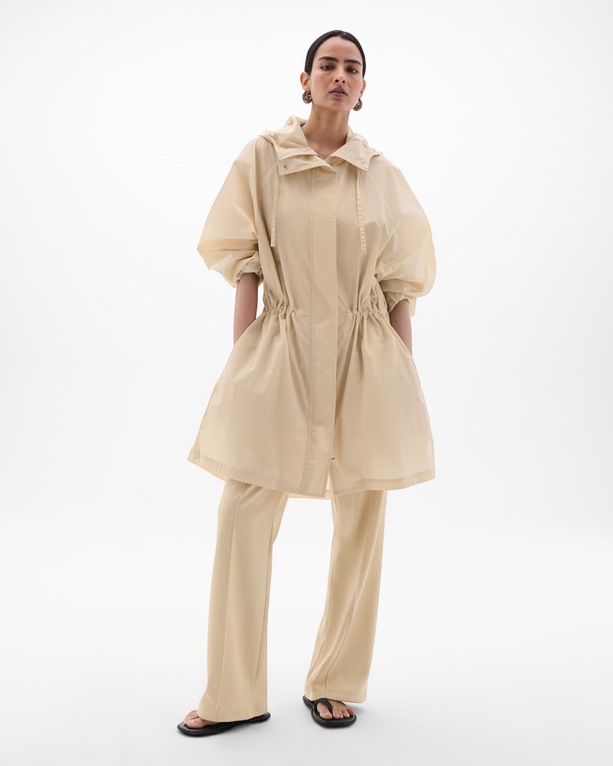 Weldun sand recycled nylon anorak with oversized hood, adjustable cuffs, and cinched waist on a model.