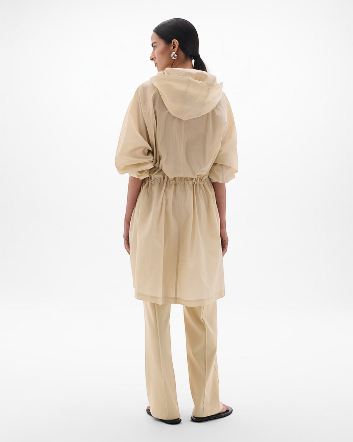Weldun sand recycled nylon anorak with oversized hood and adjustable cuffs worn by a model, back view