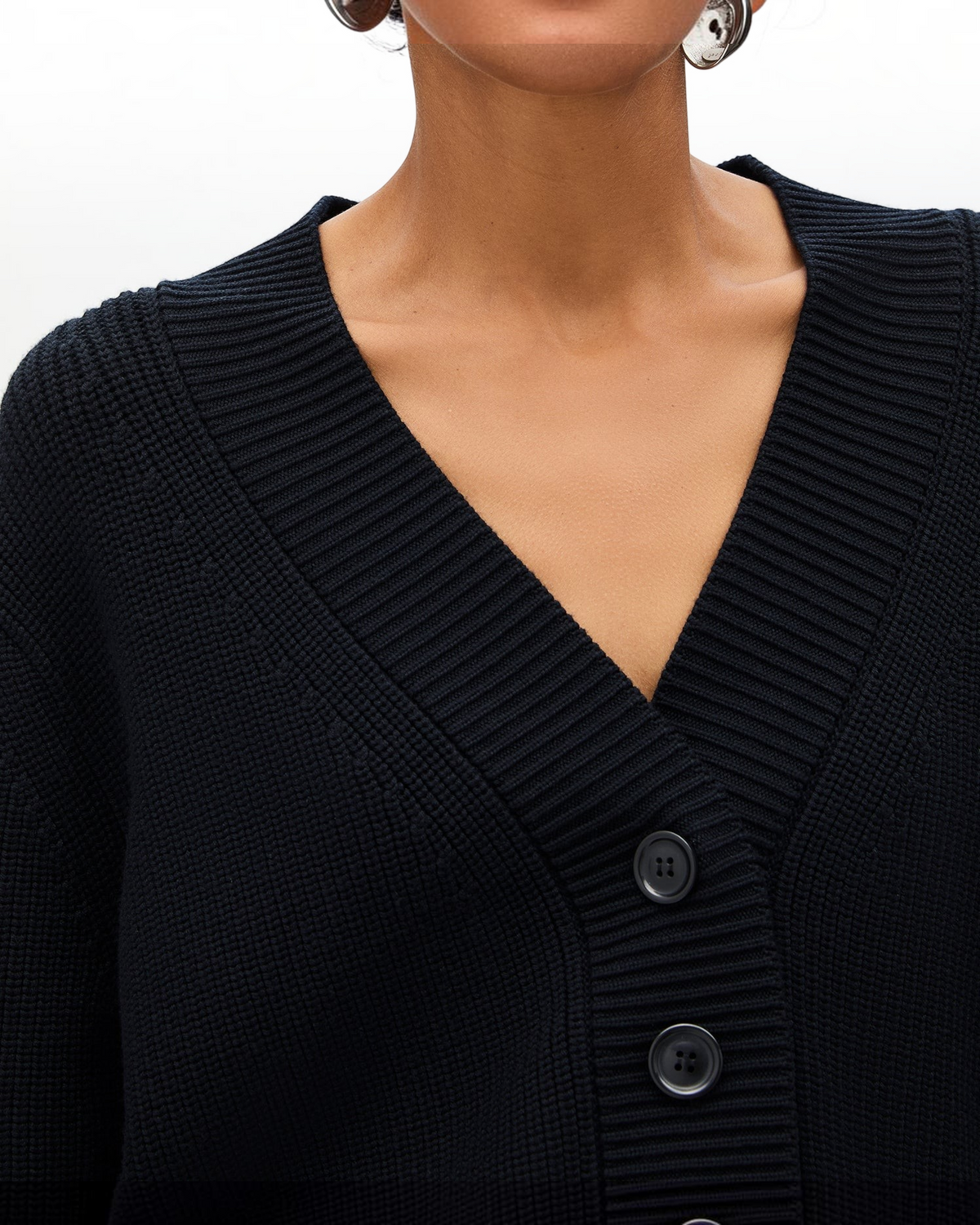 Weldun black rib cropped cardigan featuring a deep-V neckline and oversized front buttons on a model