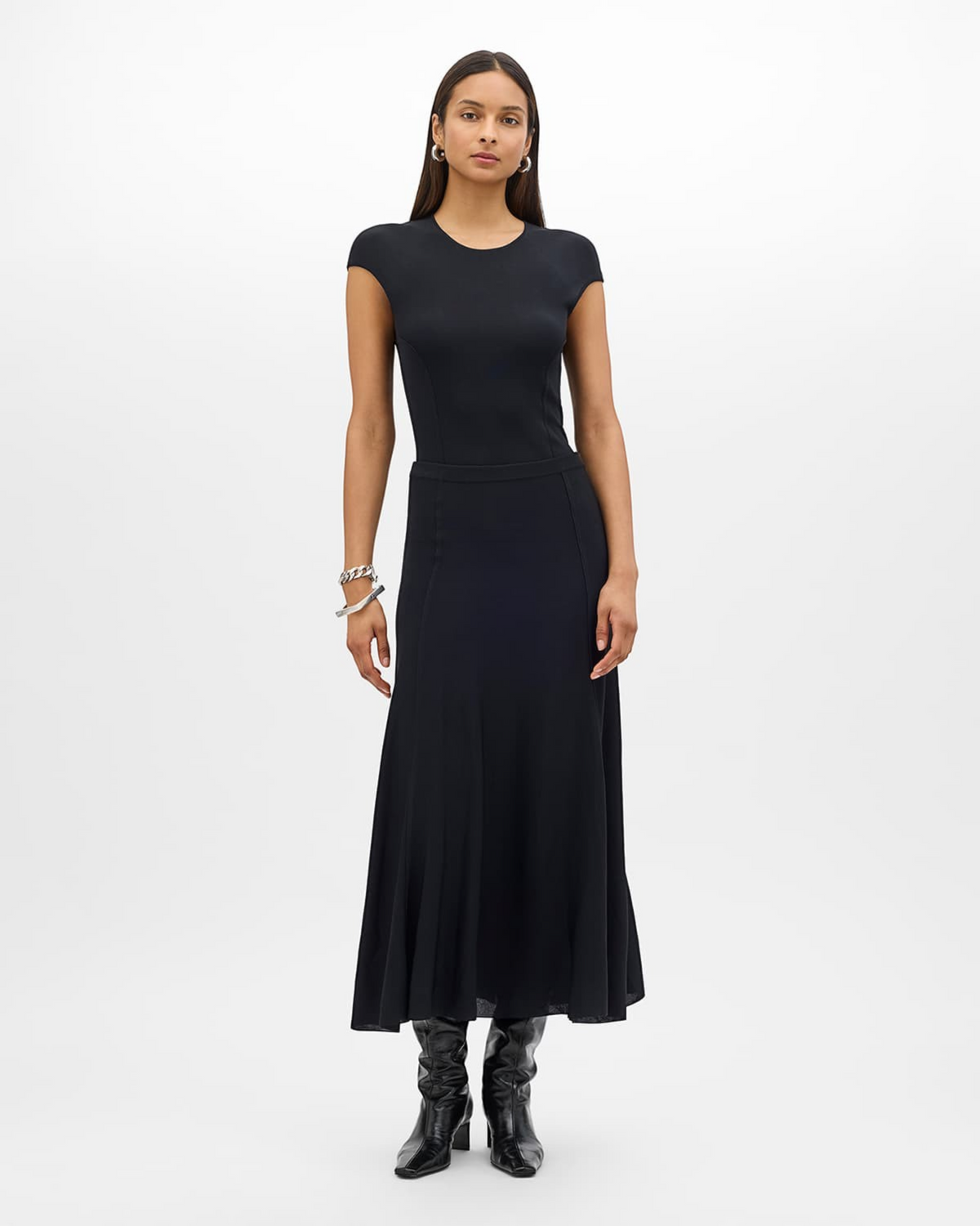 Weldun black midi length knit flare skirt with paneled seams worn by a model with a matching black cap sleeve top.