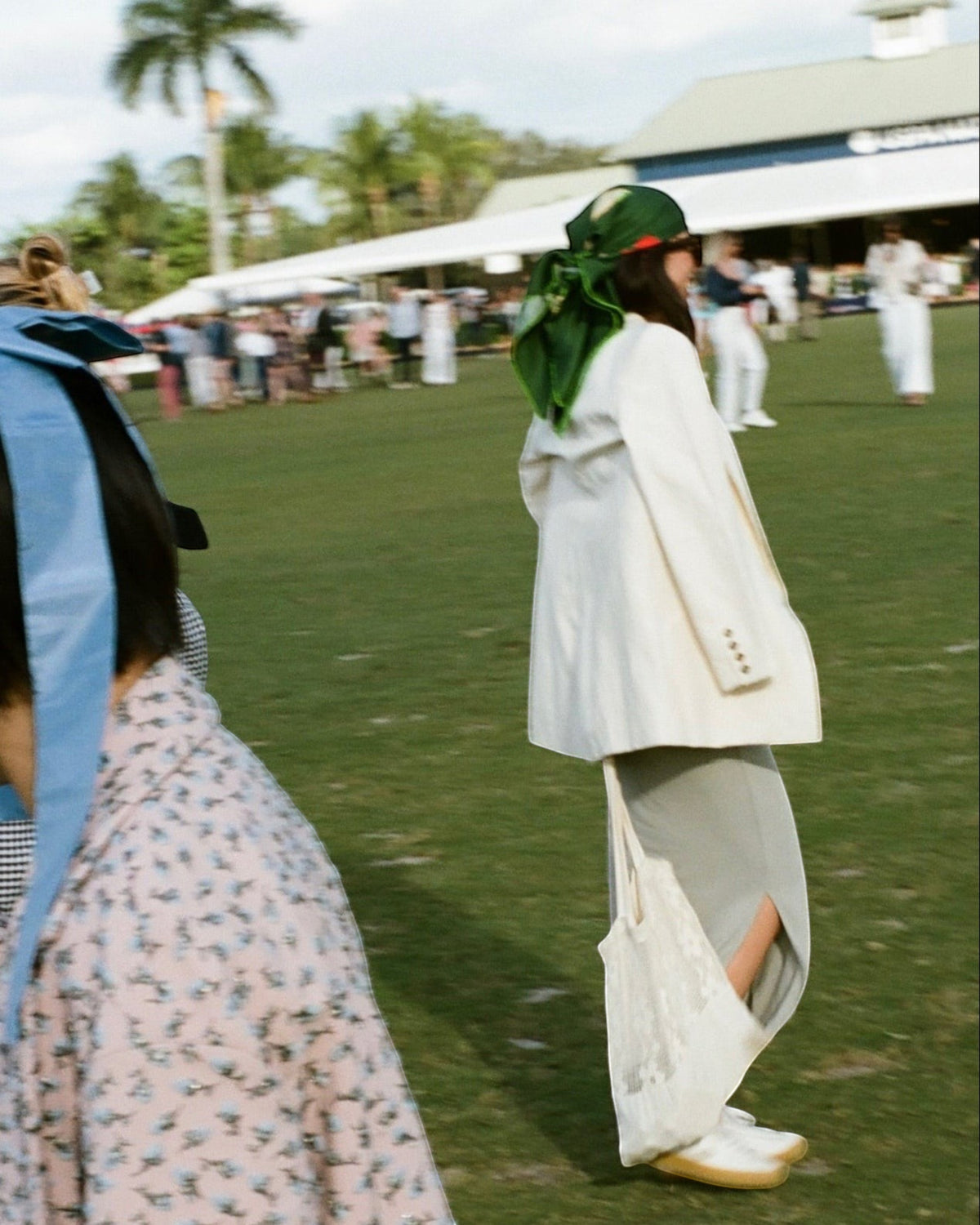 Weldun Good Girl 90 green silk twill scarf worn as a headscarf by a woman at an outdoor equestrian event
