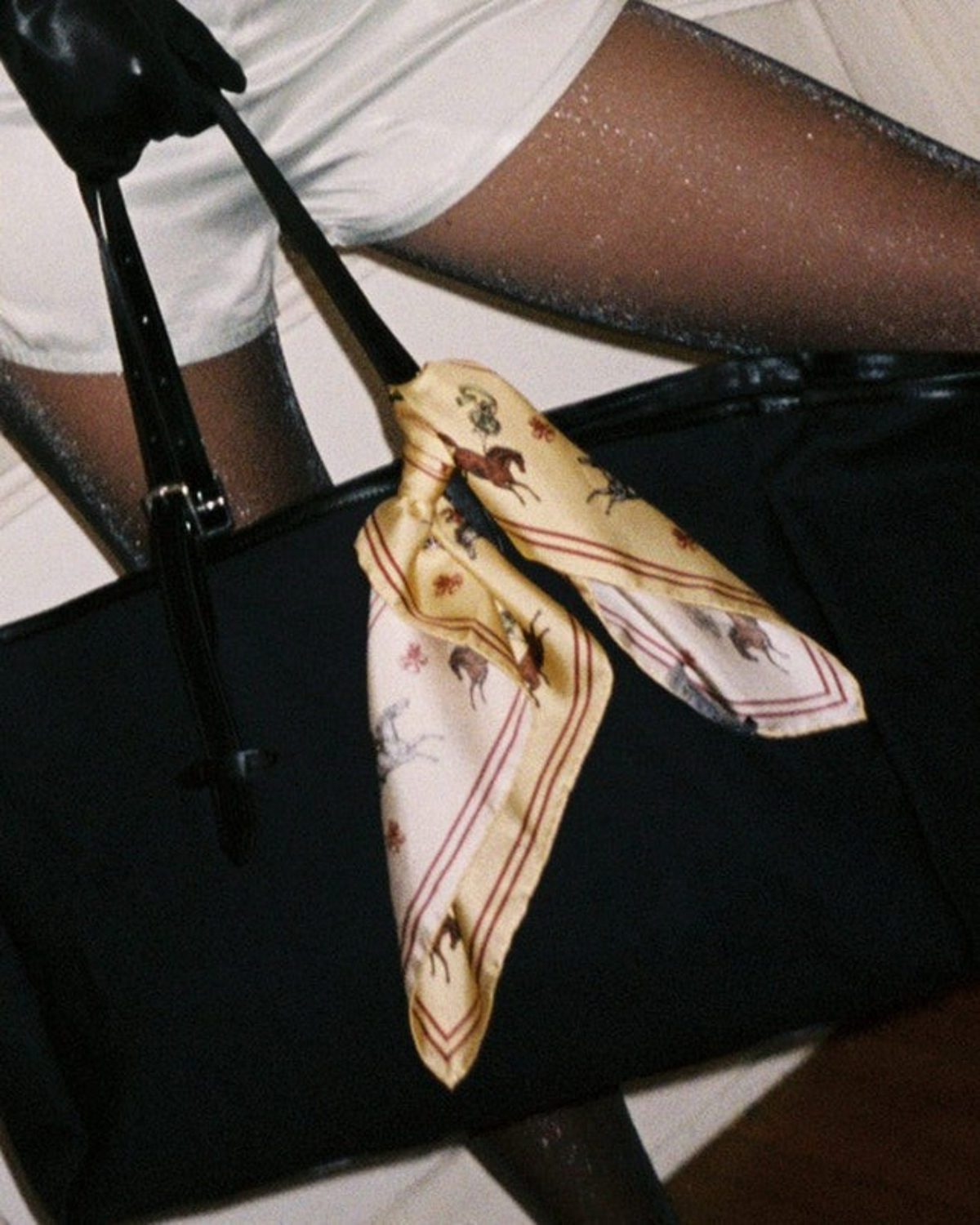 Weldun Petit Circus 55 silk twill bandana with equestrian print tied to a black handbag