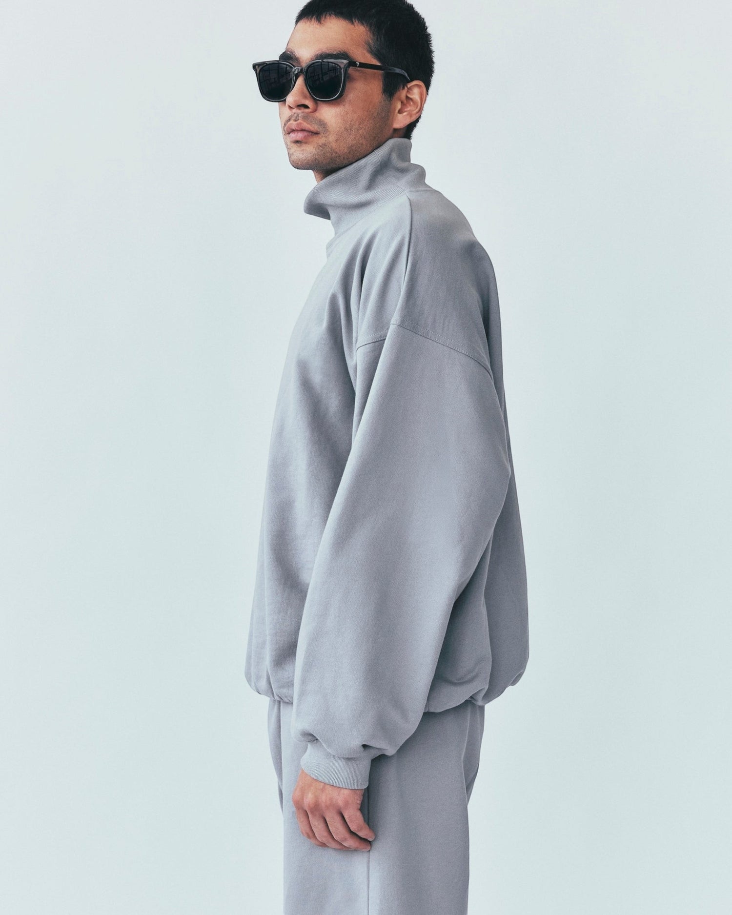 Weldun model wearing a grey organic cotton high neck sweatshirt with a relaxed boxy fit and long sleeves