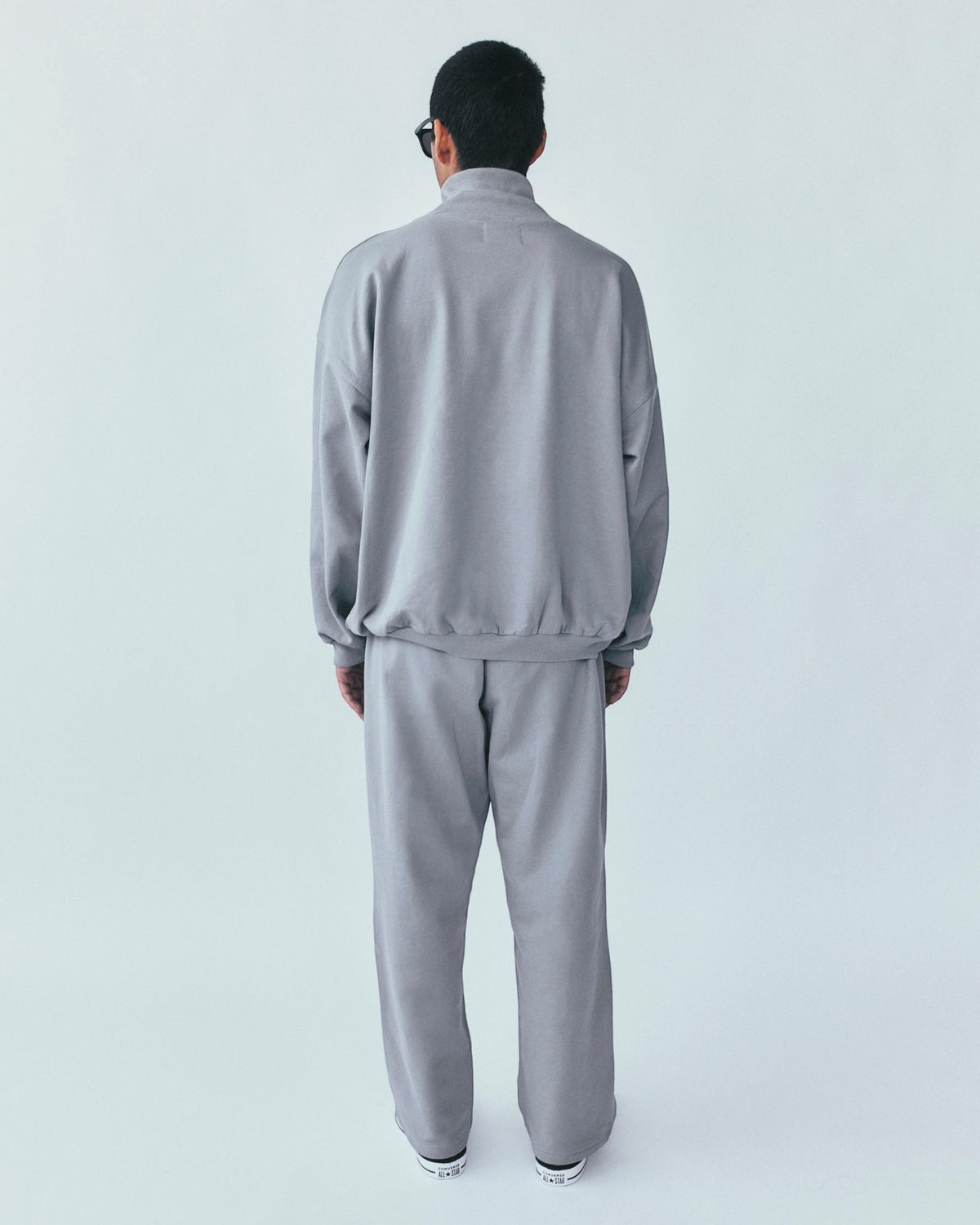 Weldun grey organic cotton sweatpants and matching sweatshirt worn by a man from the back view