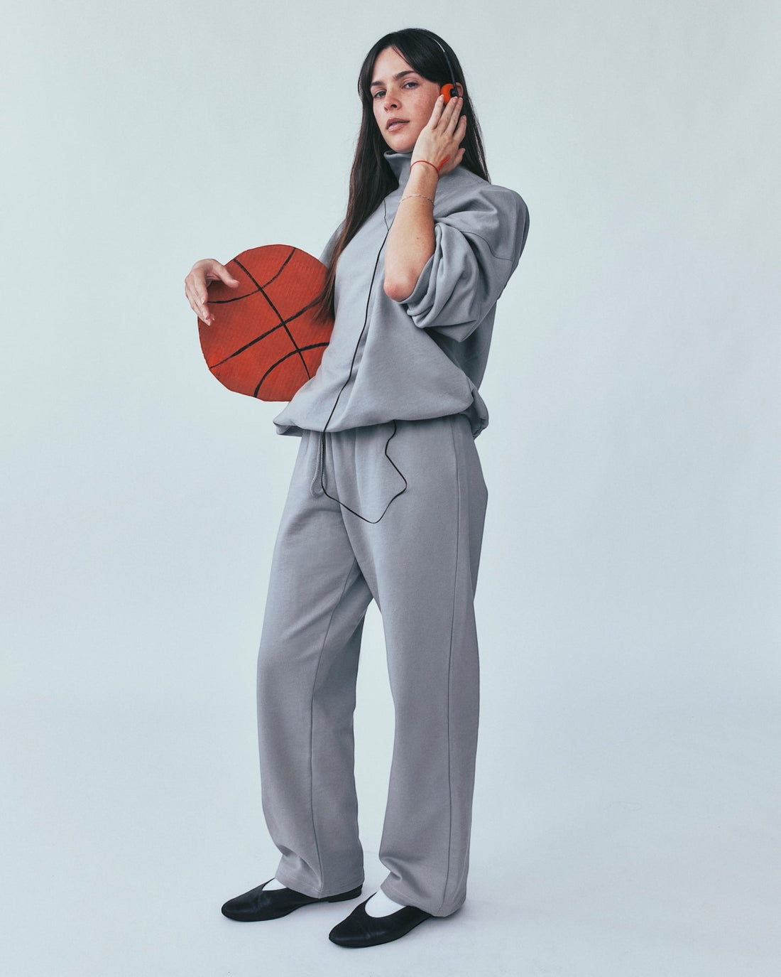 Weldun grey organic cotton sweatpants with a relaxed straight-leg fit worn by a woman holding a basketball.