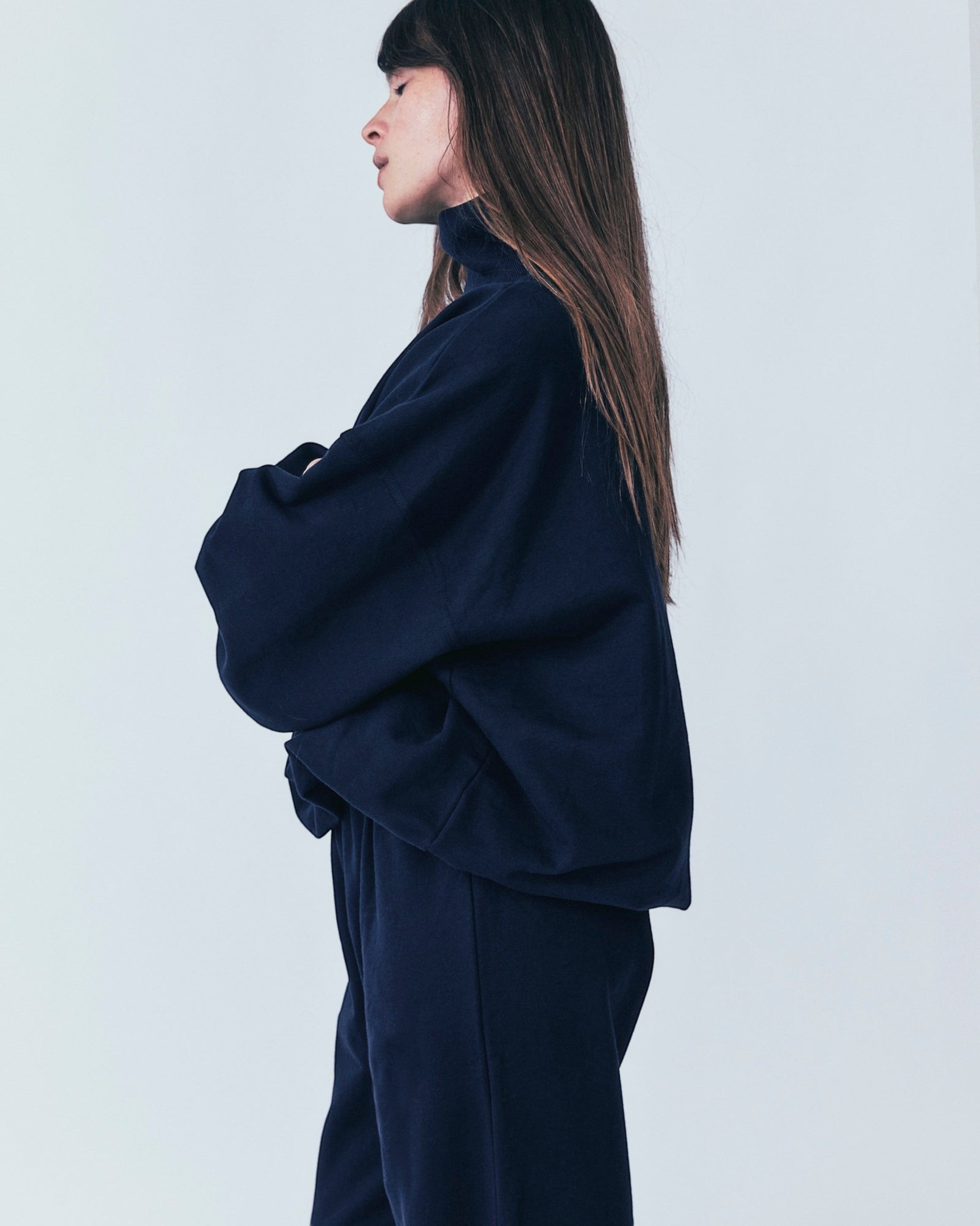 Weldun navy organic cotton high neck sweatshirt with a relaxed boxy fit worn by a woman in profile