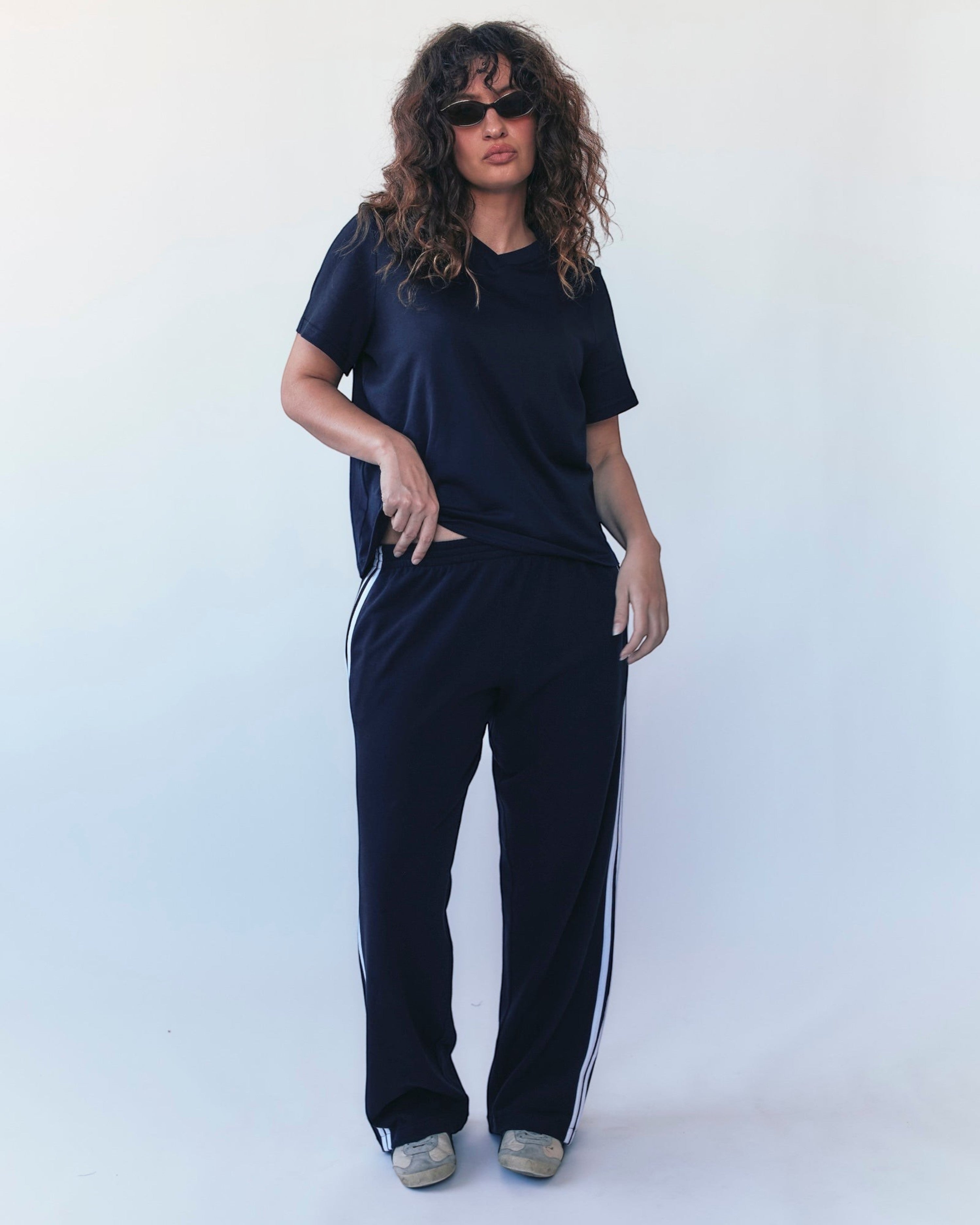 Weldun navy track pants with white side stripes in soft Japanese cotton terry worn by a model with a matching tee.