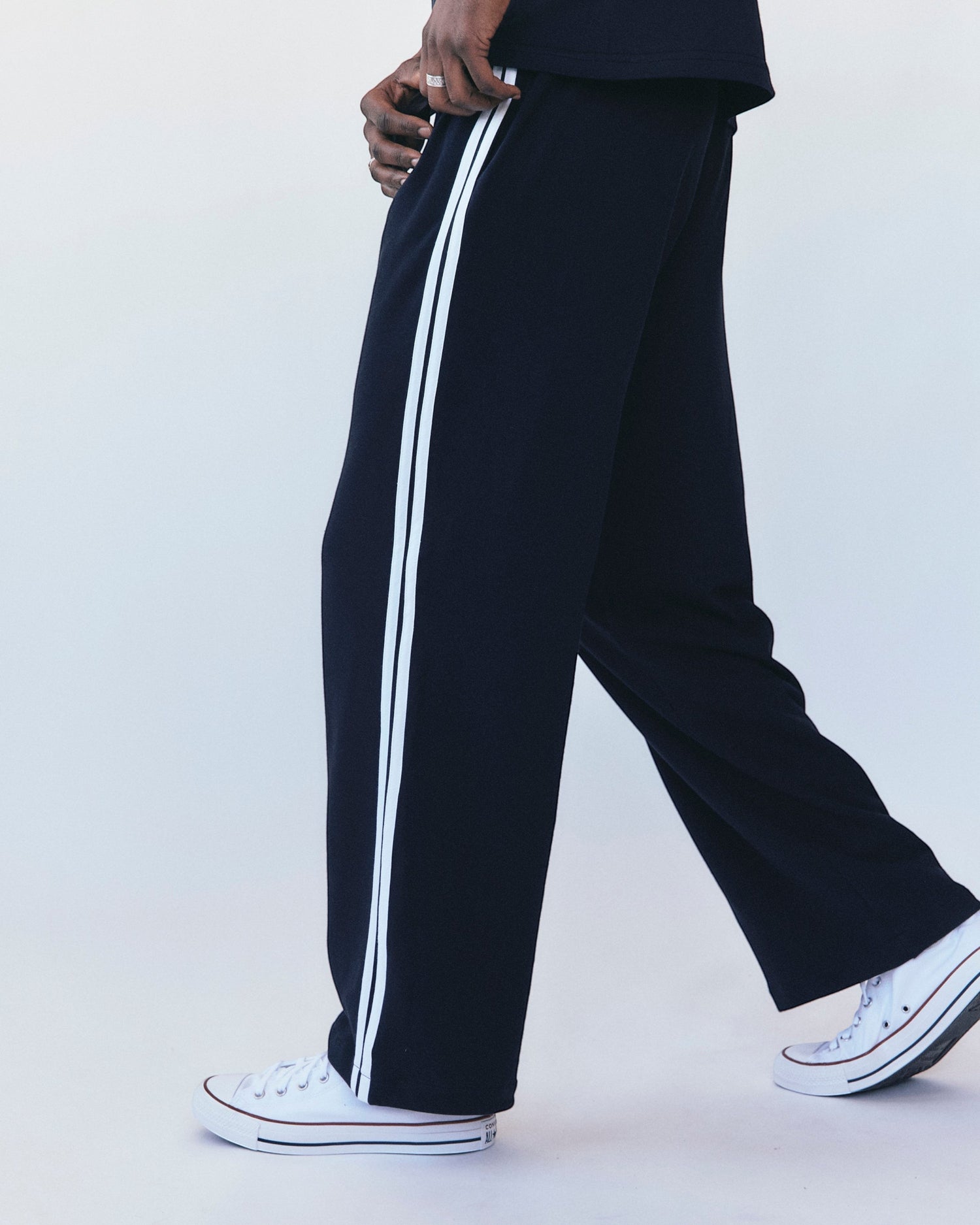 Weldun navy cotton terry track pants with white side stripes worn by a model in a relaxed fit