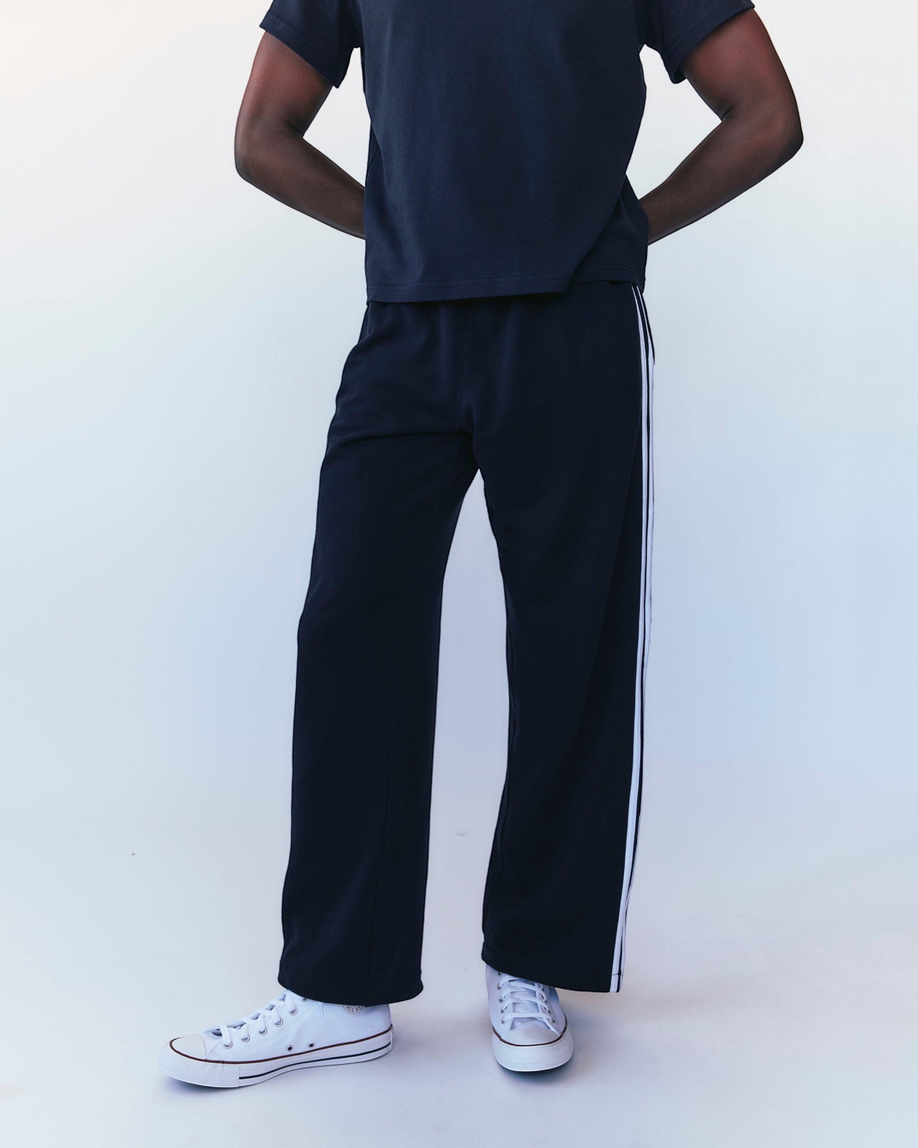 Weldun navy cotton terry track pants with white side stripes worn by a model in a relaxed fit