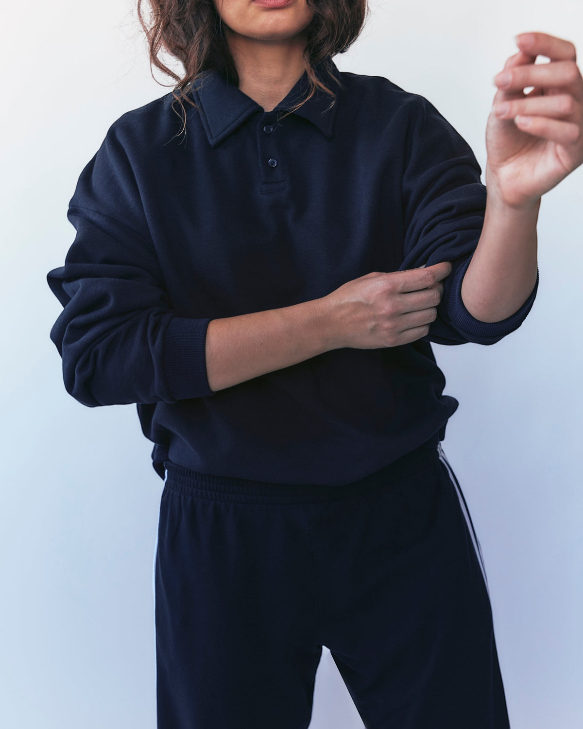 Weldun navy cotton polo sweatshirt with ribbed collar and cuffs worn by a person rolling up the sleeves
